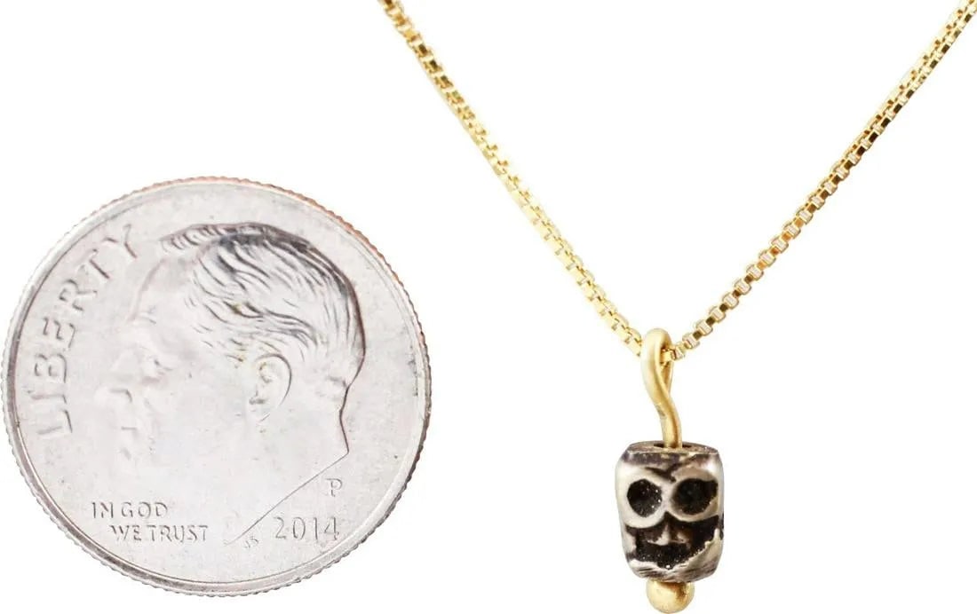 TIBETAN SKULL PRAYER BEAD C.1400-1550: This small Medieval bronze bead, hand crafted about 1400-1550 was part of a Buddhist prayer ritual. It was strung along with others, each showing differences from hand work, to aid the devotee by