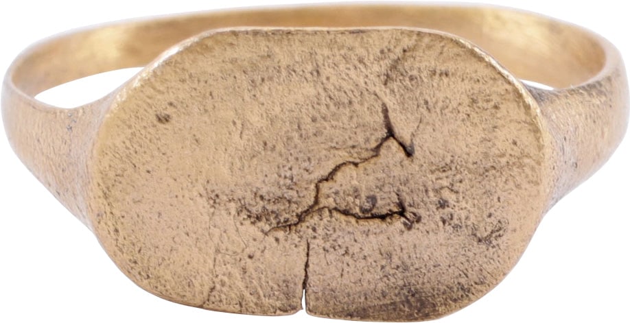 MEDIEVAL WOMAN’S RING C.6-10 C.AD.: Size 8 ¼. 2.7mm ridged band flared to the shoulders. Oval bezel inscribed with an unidentified figure or image. Perhaps a woman’s head. The motif is hand executed and probably serves as a s