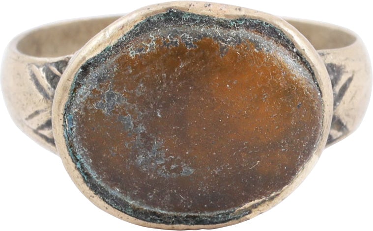 EASTERN EUROPEAN GYPSY RING, SIZE 8 1/4: 19th century. Alloy (silver?) band and bezel. The band, 3.3mm with rounded face, flaring to the chevron decorated shoulders. Stepped oval bezel with a yellow glass or stone cabochon. Some wear with