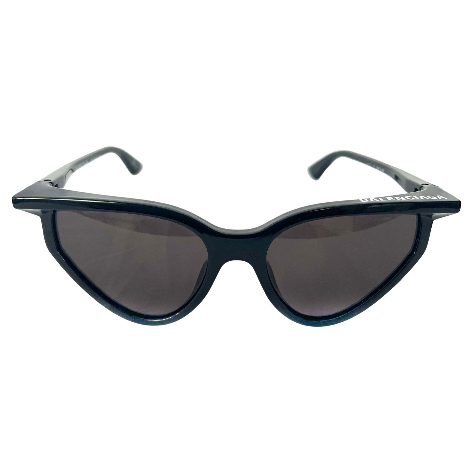 Balenciaga Black Rim Cat Eye Sunglasses: Cat eye shaped frame Black frame Black lenses Featuring white Balenciaga logo on the top left Made in Italy Includes case Reserve: $300.00 Shipping:Domestic: Flat-rate of $85.99 to