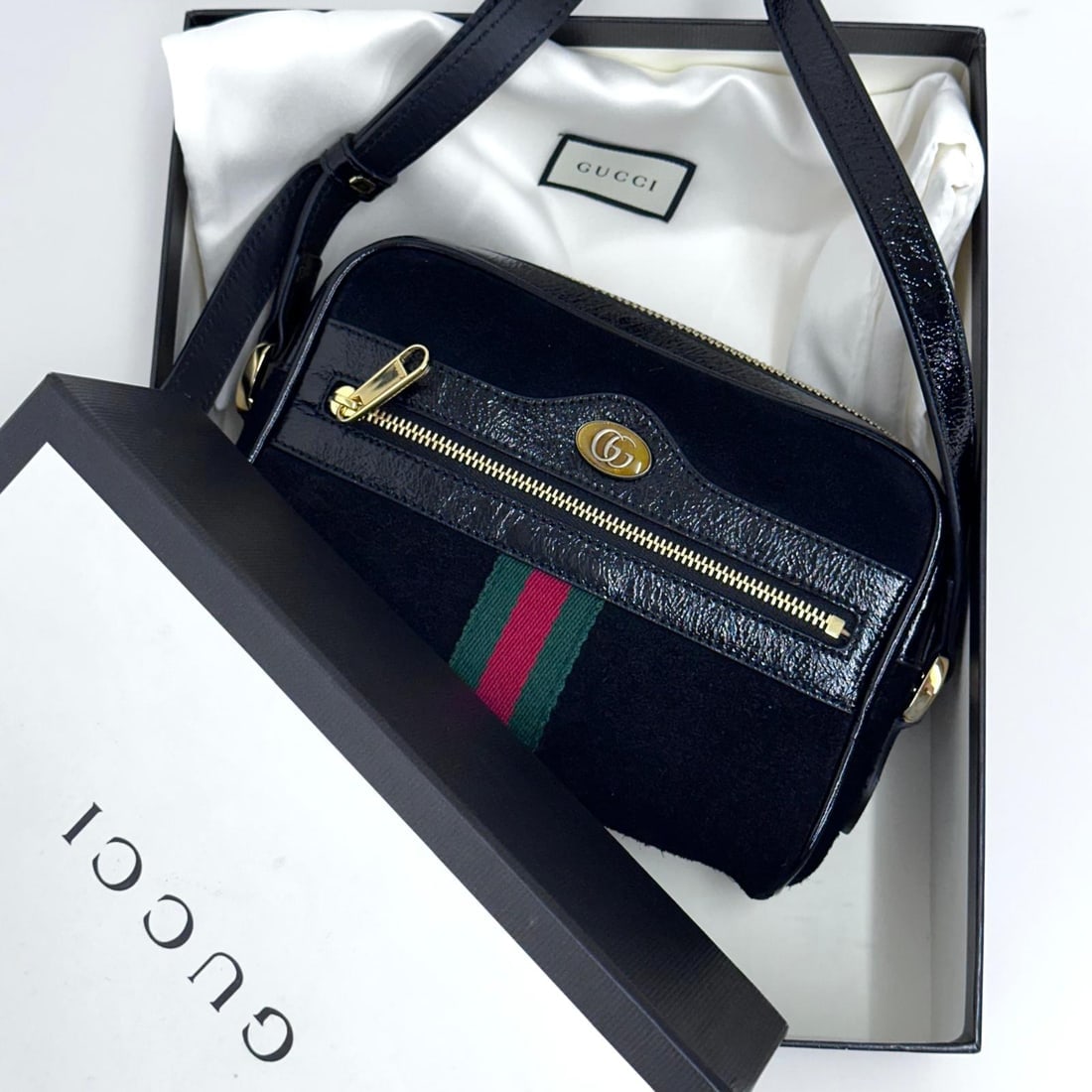 GUCCI Ophidia Small Camera Bag in Black Suede and Patent Leather.: Title:GUCCI Ophidia Small Camera Bag in Black Suede and Patent Leather.Materials:SuedeDimensions:• Length: 18 cm• Height: 12 cm• Width: 5 cmDescription:(6214B257). A Gucci icon in a