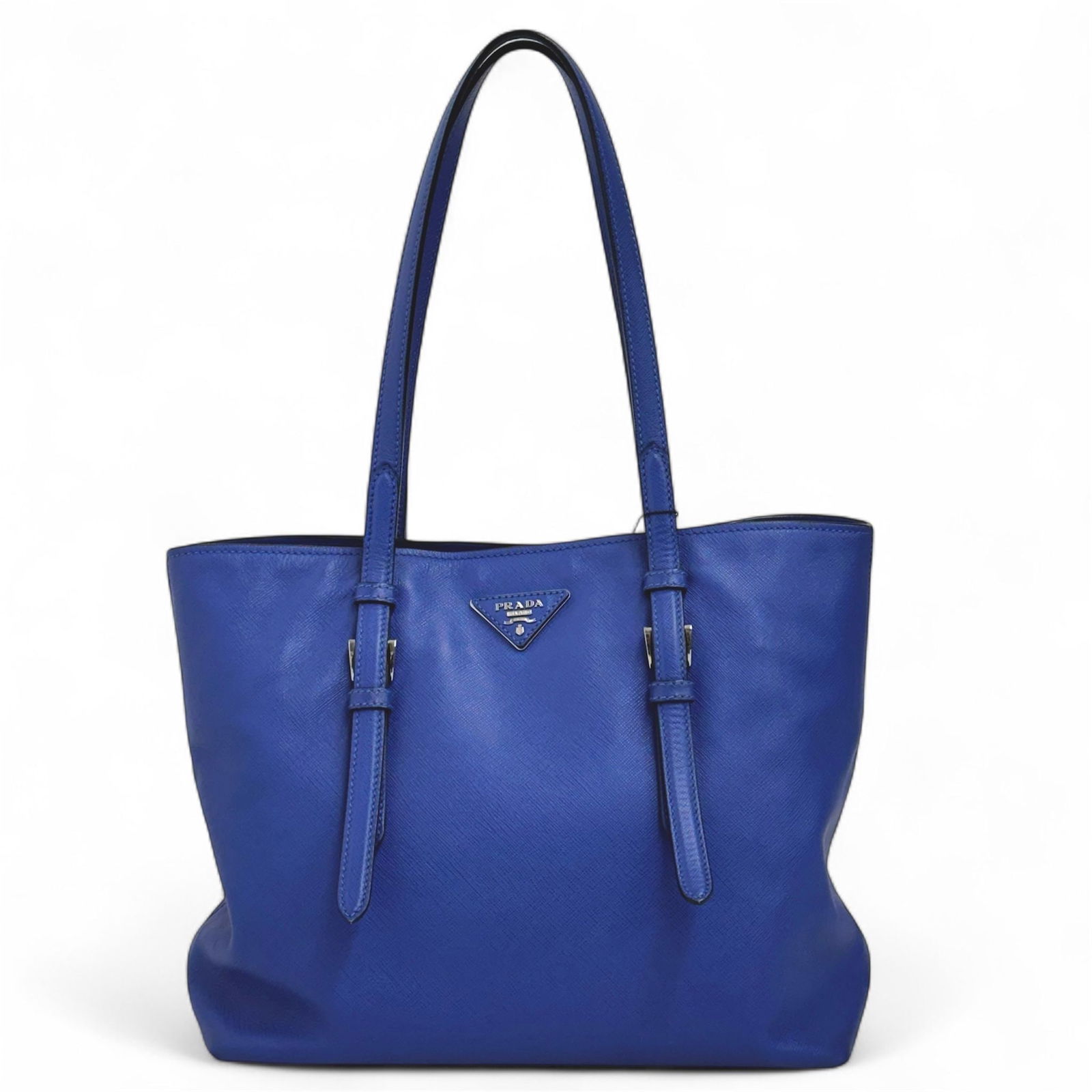 PRADA Blue Saffiano Tote Shopping Bag: Title:PRADA Blue Saffiano Tote Shopping BagMaterials:LeatherDimensions:• Length: 29 cm• Height: 25 cm• Width: 13 cm• Handles: 23 cmDescription:(6077B390). This Prada Saffiano