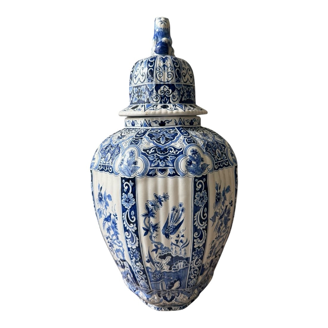 1940s Big Lidded Delft Jar With Lion Figural Lid. Bird and Floral Panels. Ribbed.: The big lidded Delft jar is a striking piece, characterized by its intricate blue and white design, typical of traditional Delftware. The jar features a prominent lid adorned with a lion griffin