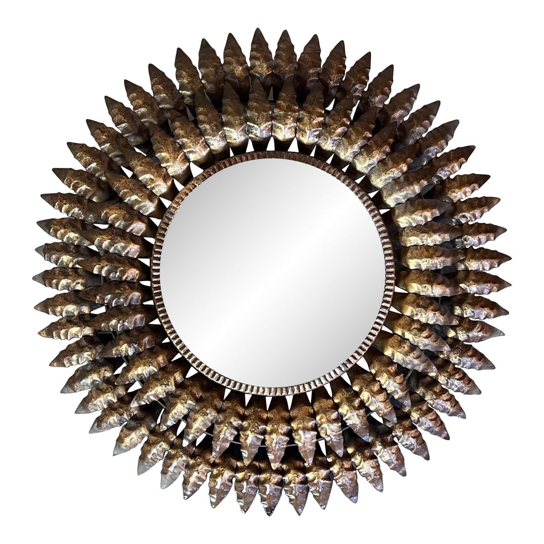 Mid 20th Century Round Spanish Gilt Metal Sunburst Mirror: A round gilt metal sunburst mirror with long narrow leaves joined closely in the middle and radiating from a solid border. The glass is original and shows sign of age. Spanish 1950's. Very good