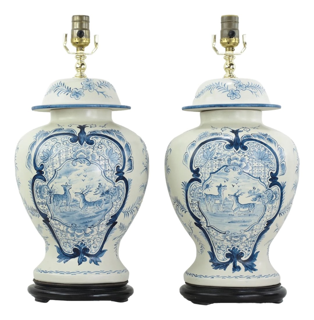 Pair of Vintage Hand Painted Blue and Cream Ceramic Ginger Jar Table Lamps With Deer and Floral Folk: This striking pair of vintage table lamps features a classic ginger jar shape with a rounded, high-shouldered silhouette and matching domed lids. Crafted from high-quality ceramic, each lamp is