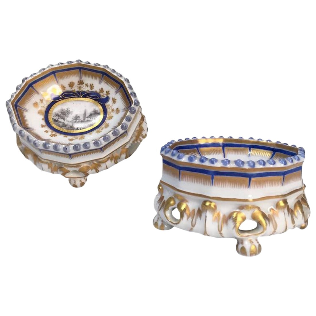 19th Century Nymphenburg Master Salt Cellars - A Pair: This pair of Master Salt Cellars has the blue under glaze mark of Nymphenburg. The scenic landscape is hand painted with great detail and skill. The painted cartouche is surrounded with a cobalt blue