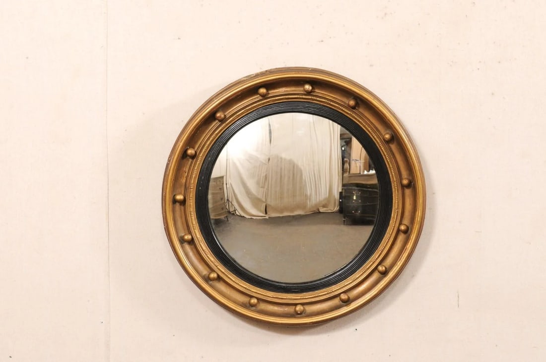 19th C. Bulls-Eye Mirror, Black & Bronze: An American carved-wood bullseye accent mirror in black and bronze/gold, from the 19th century. This antique mirror features a round/convex glass center, set within in circular carved-wood frame, ador