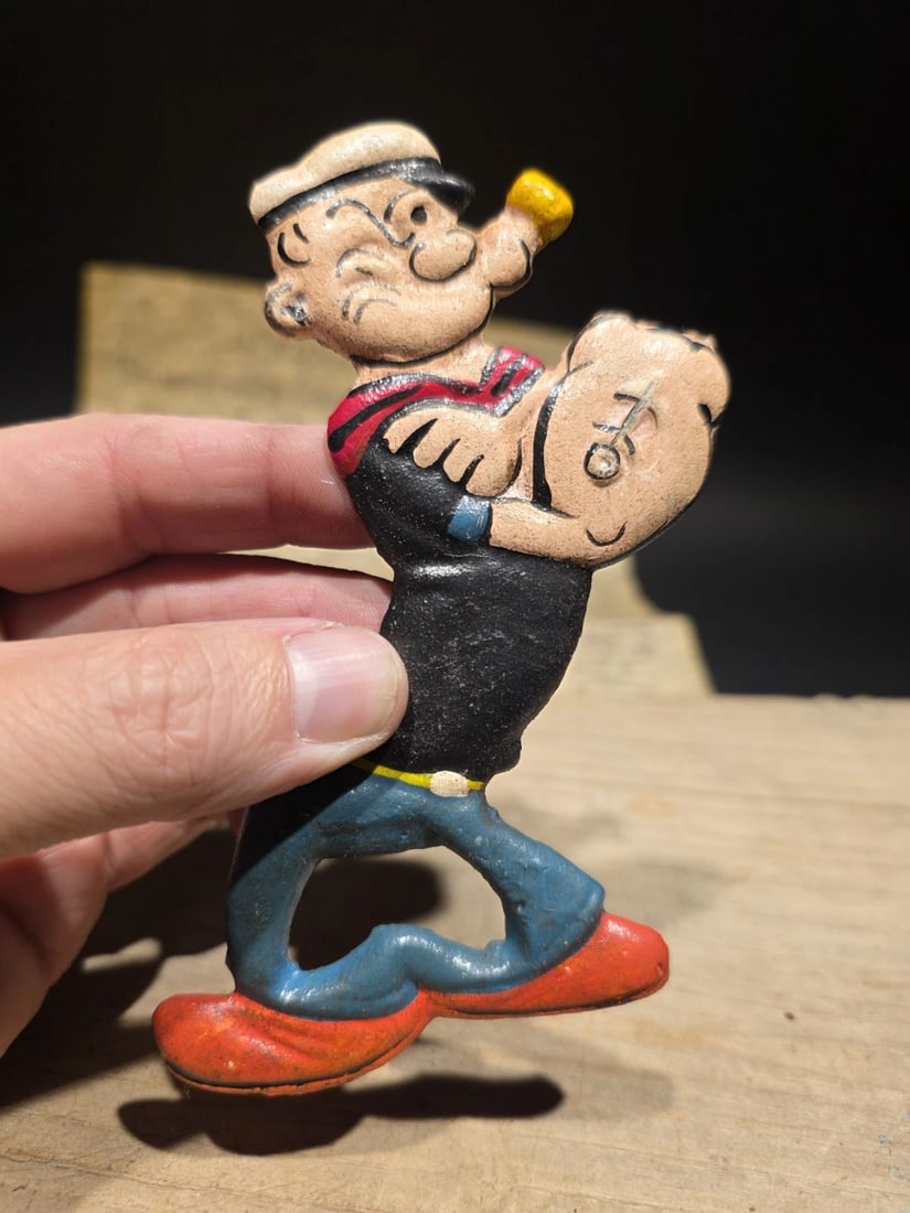 5" Cast Iron Popeye Bottle Opener: Title:5" Cast Iron Popeye Bottle OpenerDescription:5" Long Nice reproduction bottle opener. Nice aged red color. All cast iron. Hard to tell its age! Reserve: $23.00 