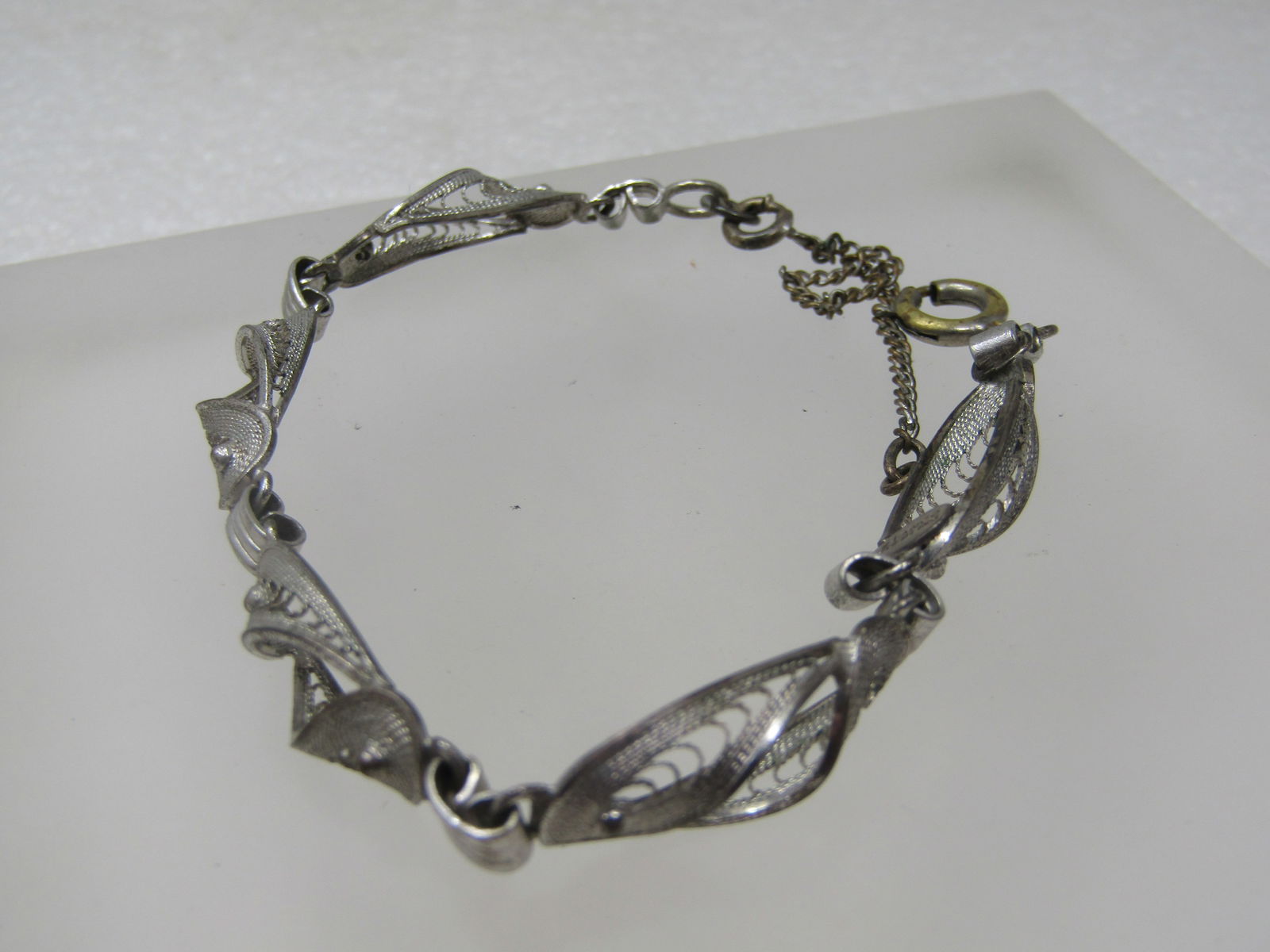 Vintage Sterling Filigree Link Bracelet, Stanco, Safety Chain 7".: Vintage Sterling Filigree Link Bracelet, Stanco, Safety Chain 7". 1940's. Curved and bead accented petal shaped links with open work and a ridged connect link. The one clasp may be a replacements as i