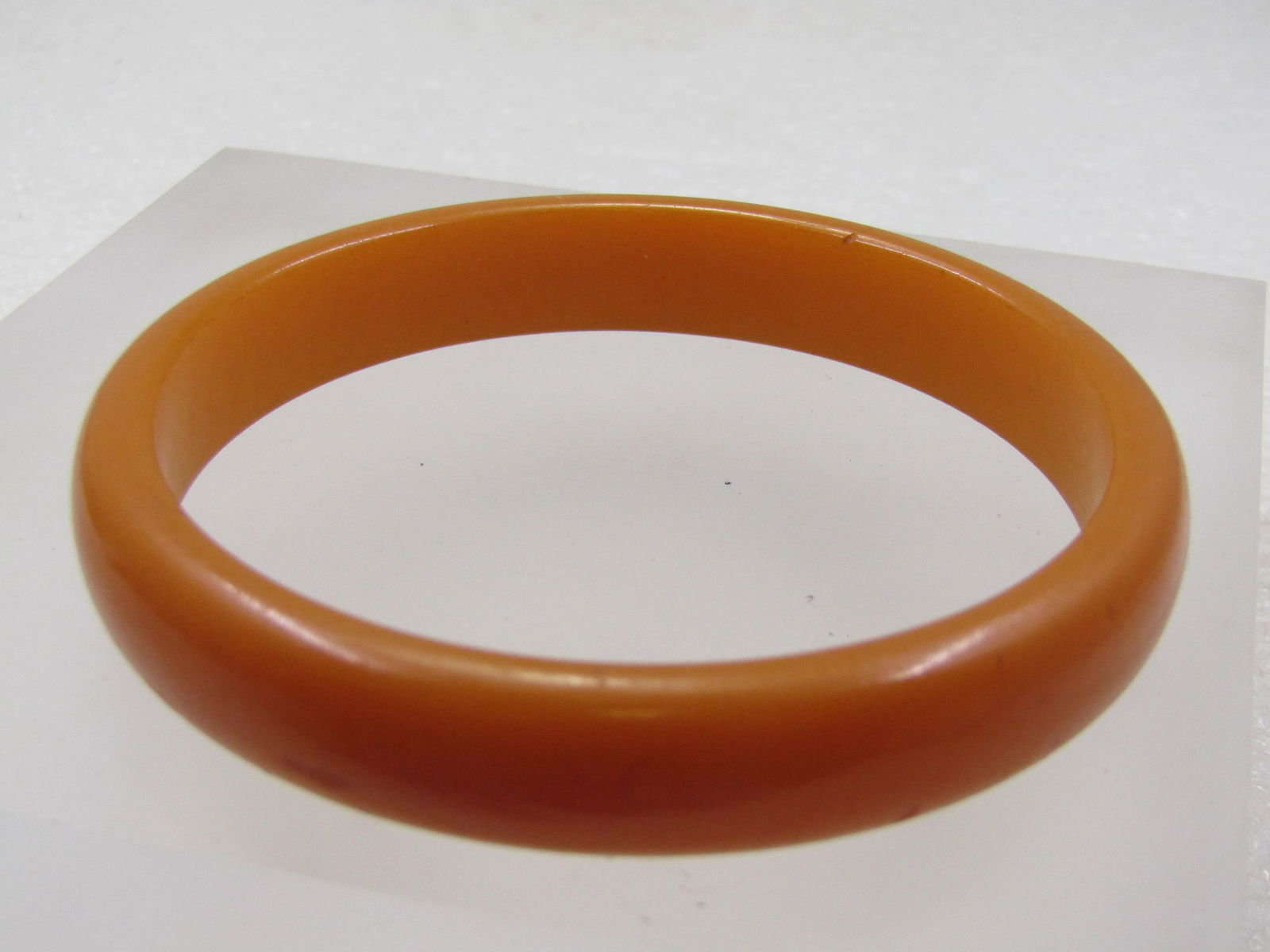 Vintage Butterscotch Lucite Bracelet, 8", 1960's: Vintage Butterscotch Bakelite Bracelet, 8", 1940''s-1950's. The bracelet is appx. 12mm wide and domedon the outer edge and flat on the inner edge, rounded on the sides. As with bakelite, it is not