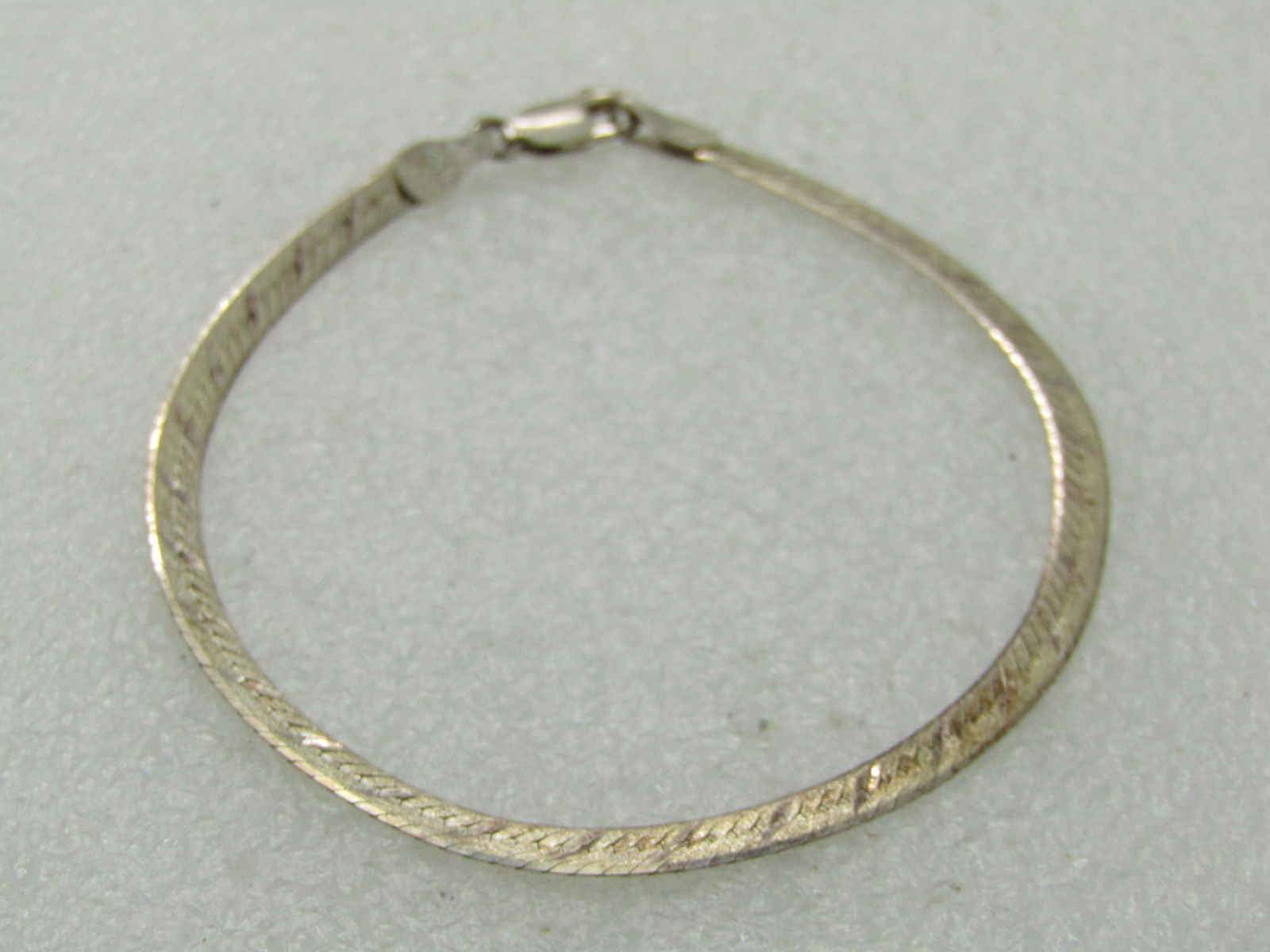 Vintage Sterling Herringbone Bracelet, 3mm Etched/Herringbone, Signed OR, 7": Vintage Sterling Herringbone Bracelet, 3mm Etched/Herringbone, Signed OR, 7" and 3mm wide. Weight is appx. 3.0 gr. Signed with OR inside heart. Lobster clasp. One side is herringbone and the other is