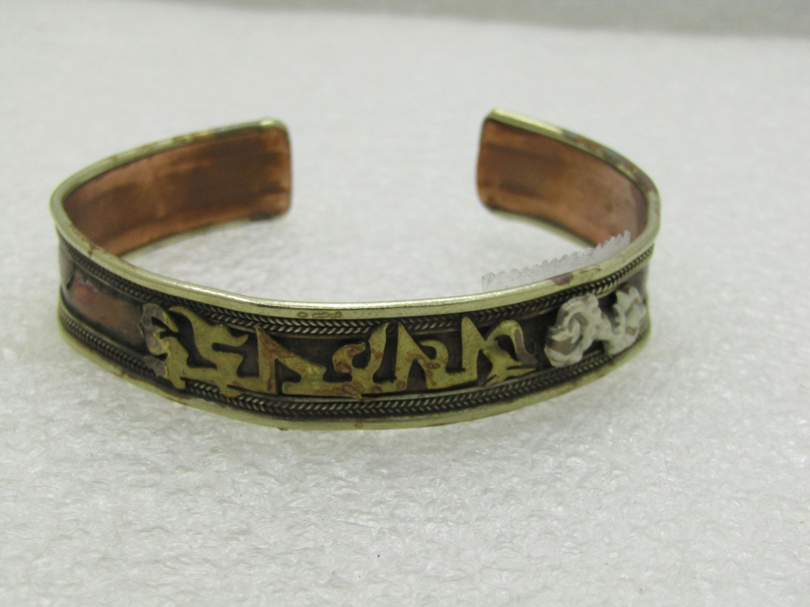 Vintage Copper MId-Eastern Wording Cuff Bracelet, 7": Vintage Copper MId-Eastern Wording Cuff Bracelet, 7" and appx. 3/8" wide. This is missing a silver accent on the side of the wording on one side. The wording is in brass with silver accents and