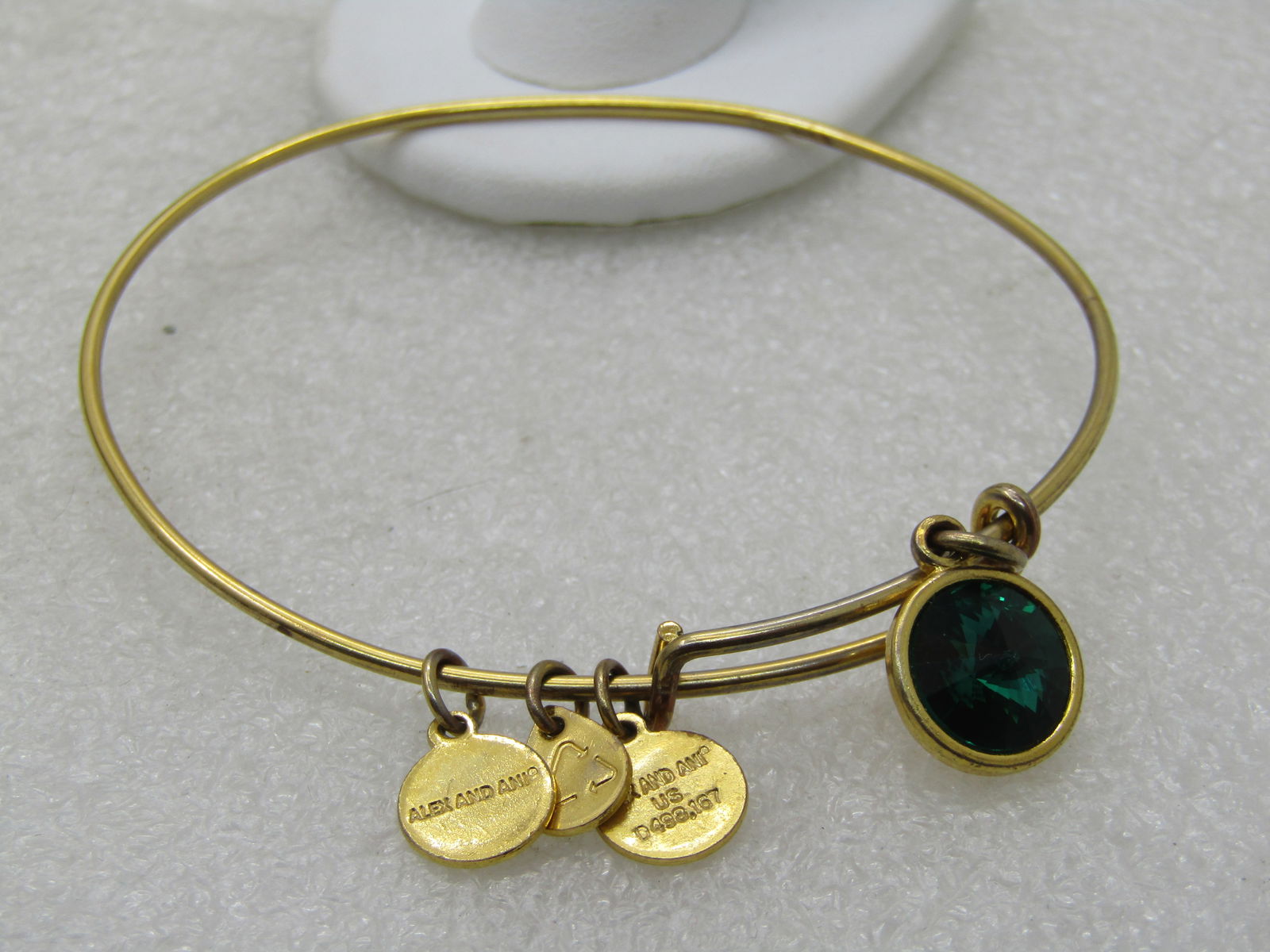 Alex and Ani Emerald Rhinestone Slide Bangle Bracelet, 8" and Under: Alex and Ani Emerald Rhinestone Slide Bangle Bracelet, 8" and lower. This has a slide that allows the bracelet to open wider. It has an appx. 10mm emerald colored pointed faceted crystal/rhinestones
