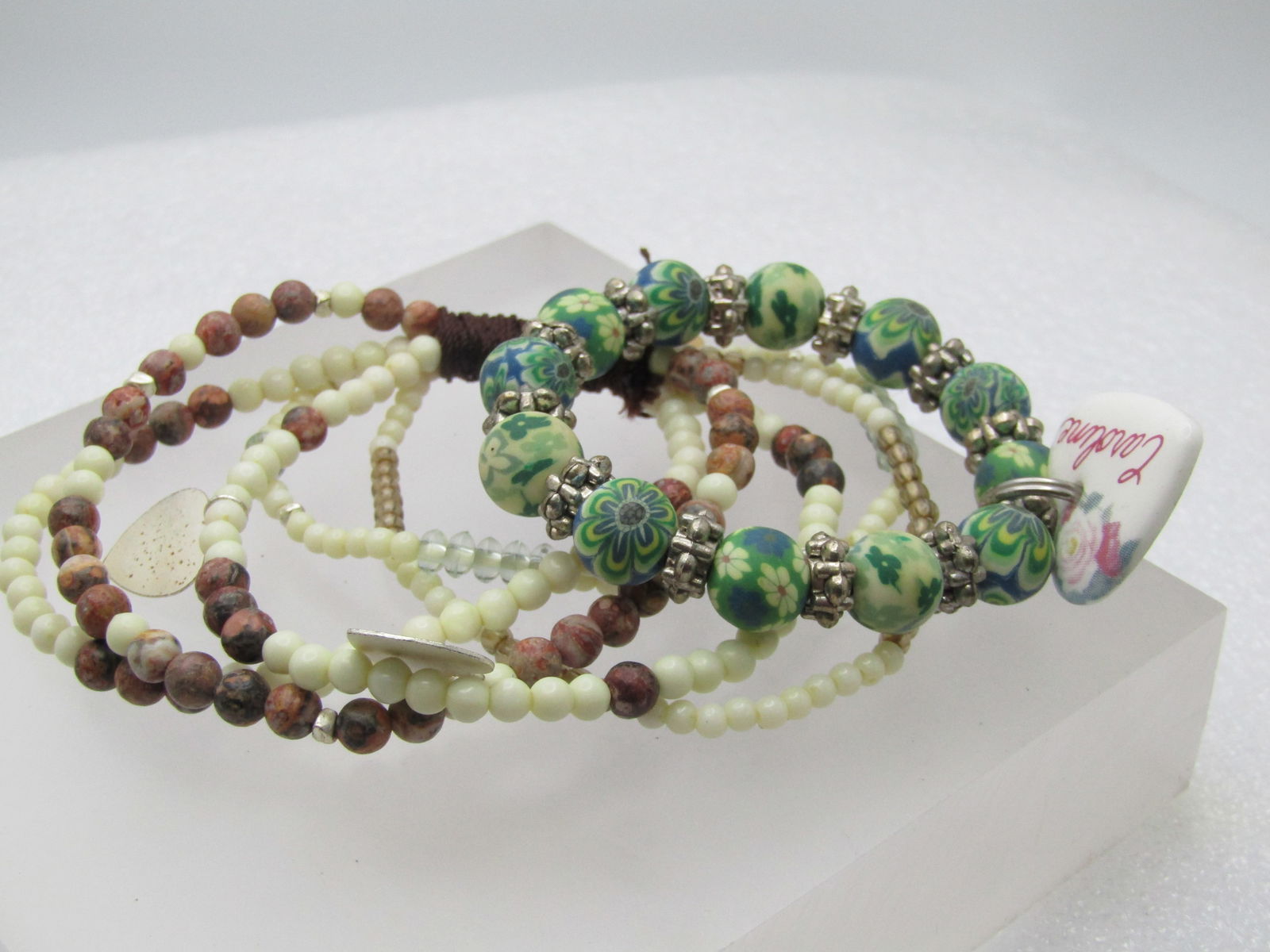 Vintage Two Beaded Stretch Bracelets, Heart Charms, 1990's: Vintage Two Beaded Stretch Bracelets, Heart Charms. One has a floral charm "Caroline" with green resin type floral beads and silver tone fluted beads - made for a 6" wrist or under. The other is a fiv
