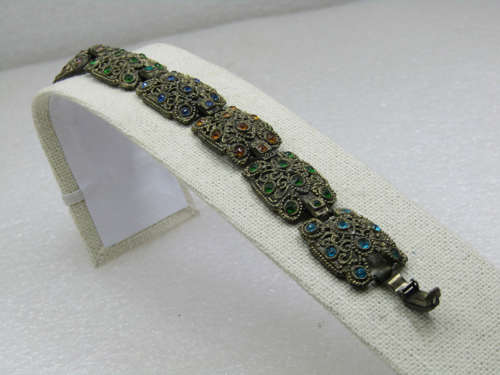 Vintage Rhinestone 1930's Gold Tone Bracelet, 7.5": Vintage Rhinestone 1930's Gold Tone Bracelet, 7.5". Eight links with pink, blue, green, yellow and aqua rhinestones. Connector link between with a rhienstone as well and three in the flip clasp - one