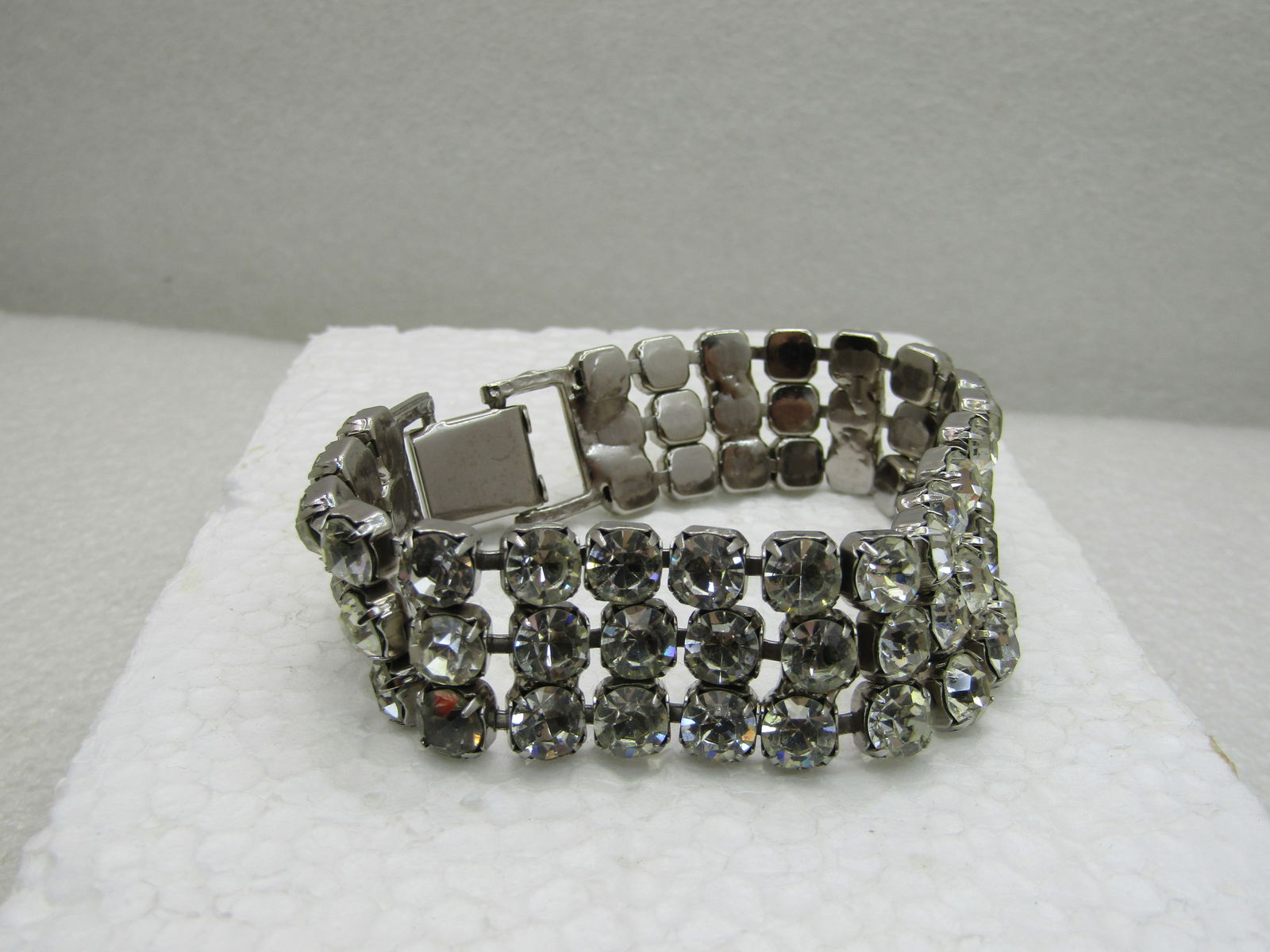 Vintage Triple Row Clear Rhinestone Bracelet, 8", Art Deco: Vintage Triple Row Clear Rhinestone Bracelet, 8", appx 7/8" wide. Three rows of appx. 6mm clear stones. There are about 3-4 stones that are slightly darker. Art Deco, wide flip clasp. Age is appx. Mid