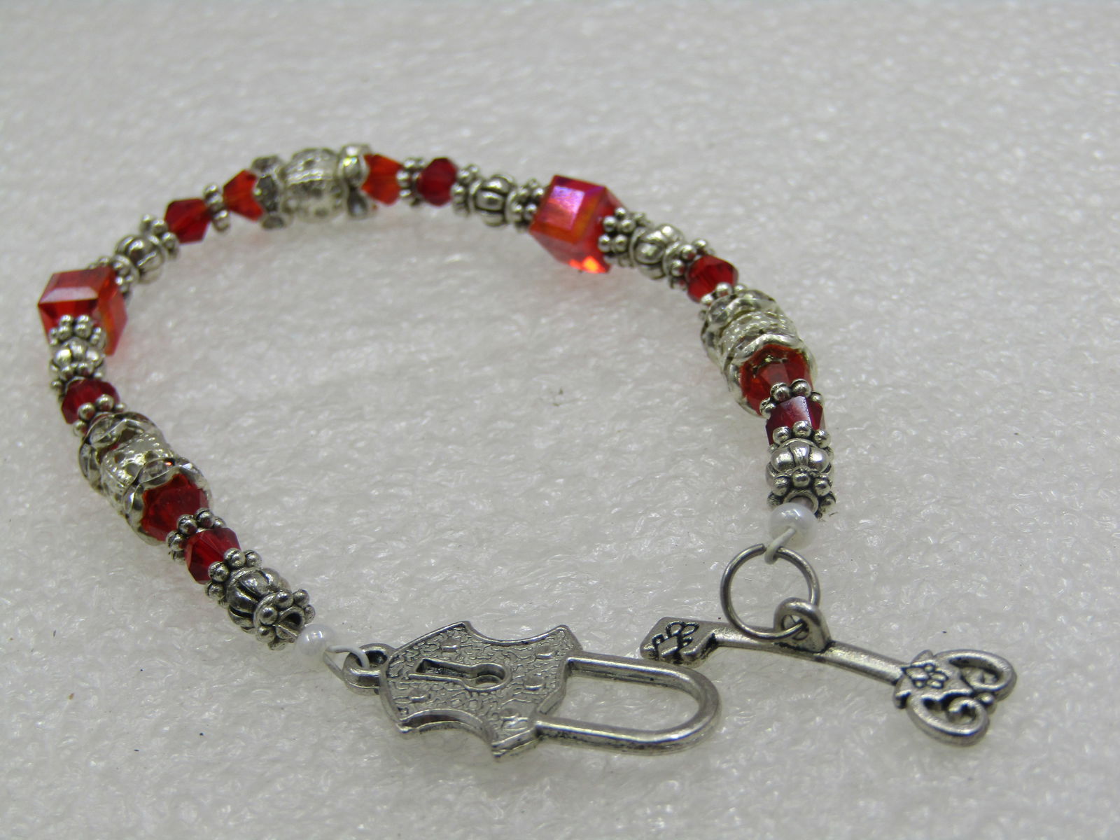 Vintage Silver Tone & Red Crystal Beaded Bracelet, Lock Toggel Clasp, 7": Vintage Silver Tone & Red Crystal Beaded Bracelet, Lock Toggel Clasp, 7". Square faceted and round faceted red glass/crystal beads with silver tone fluted beads and some with rhinestones. Mixed sizes