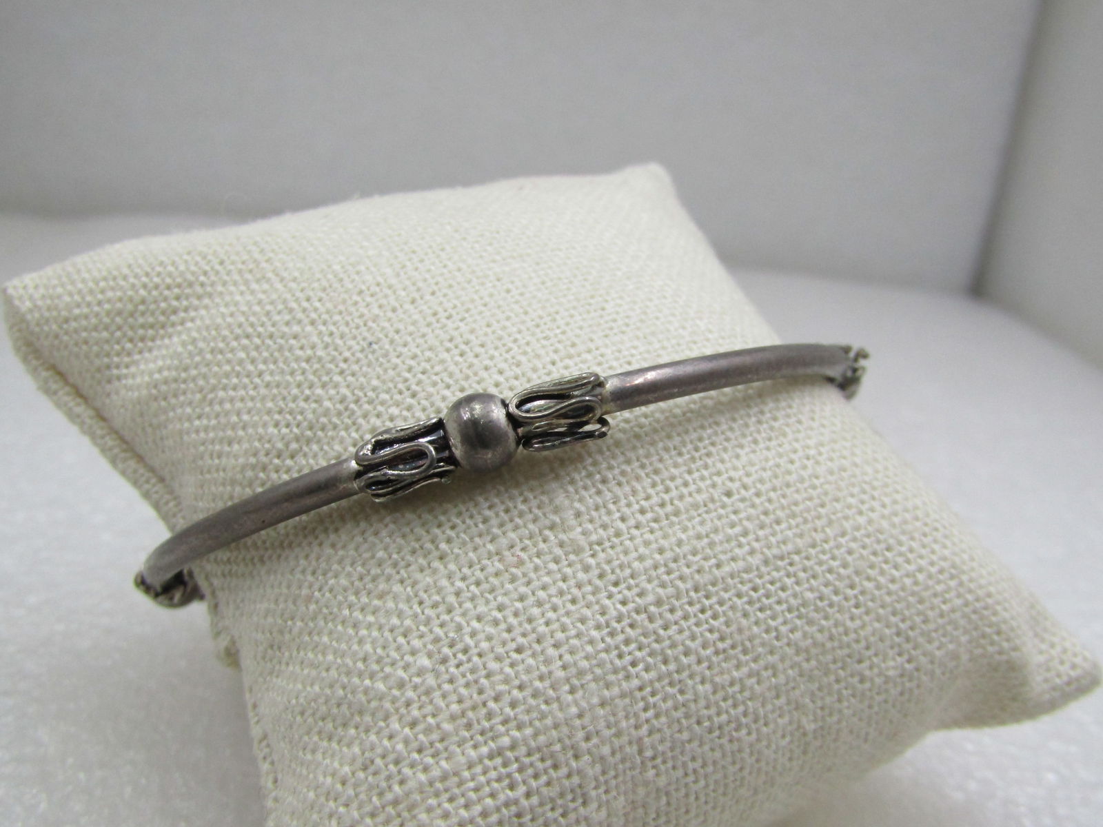 Vintage Silver Tone Bali Bangle Bracelet, 8.25": Vintage Silver Tone Bali Bangle Bracelet, 8.25", 1960's-1970's. Silver tone alloy with four bali-style accents evenly space around the nearly 3mm tubular bracelet. The accents are slightly wider at 5m