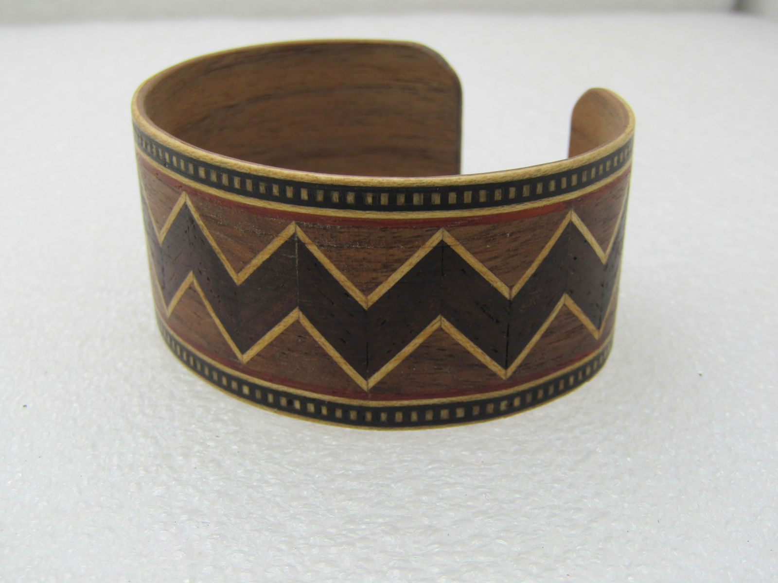 Vintage Tribal Inlaid Wooden Cuff Bracelet, 7.25", 1-1/8" Wide, Unisex: Vintage Tribal Inlaid Wooden Cuff Bracelet, 7.25", 1-1/8" Wide, Unisex. Opening is 2.5" by 2". Zig-zag inlaid design around the center of the bracelet with a dotted border. Done in shades of brown. Po