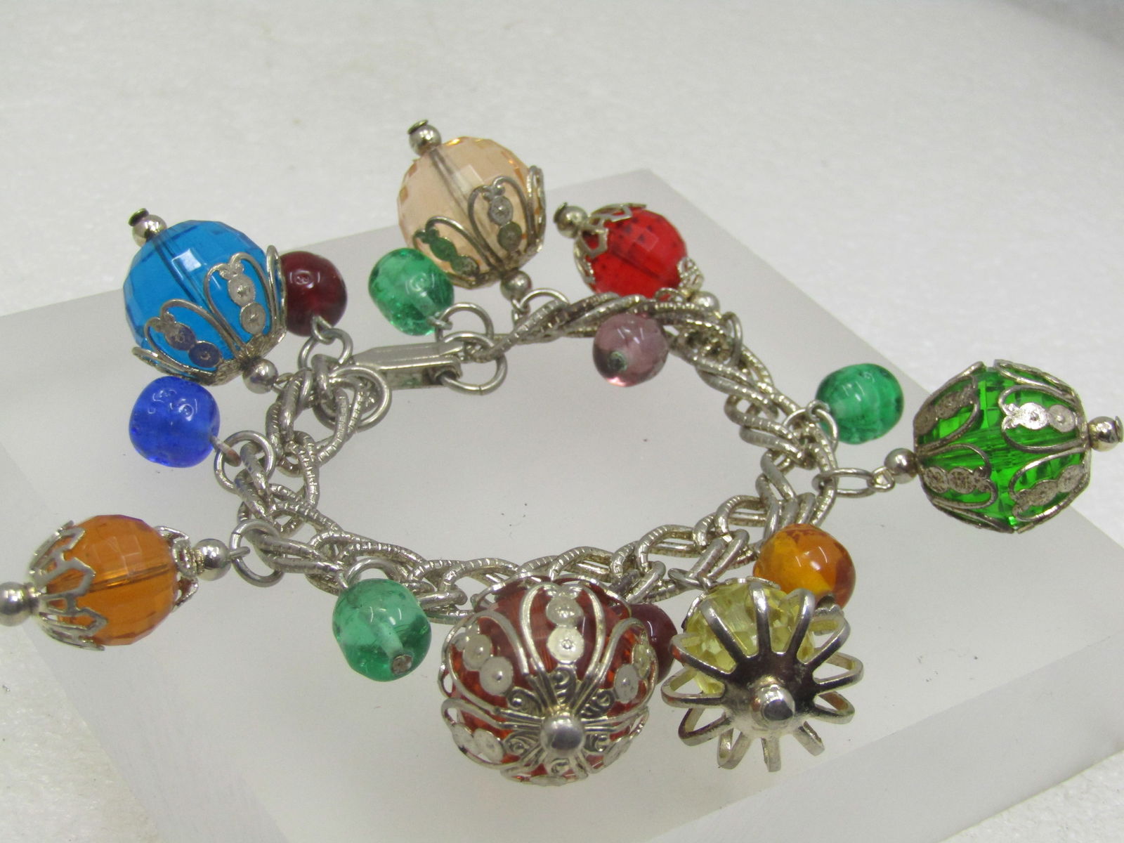 Vintage Gemtone Beaded Bracelet, 7", 1950's-1960's, Filigree Capped: Vintage Gemtone Beaded Bracelet, 7", 1950's-1960's, Filigree Capped. A mix of faceted lucite beads that range from 12.5mm to 18mm in gemtone colors and some have fiilgree caps on top and bottom (the