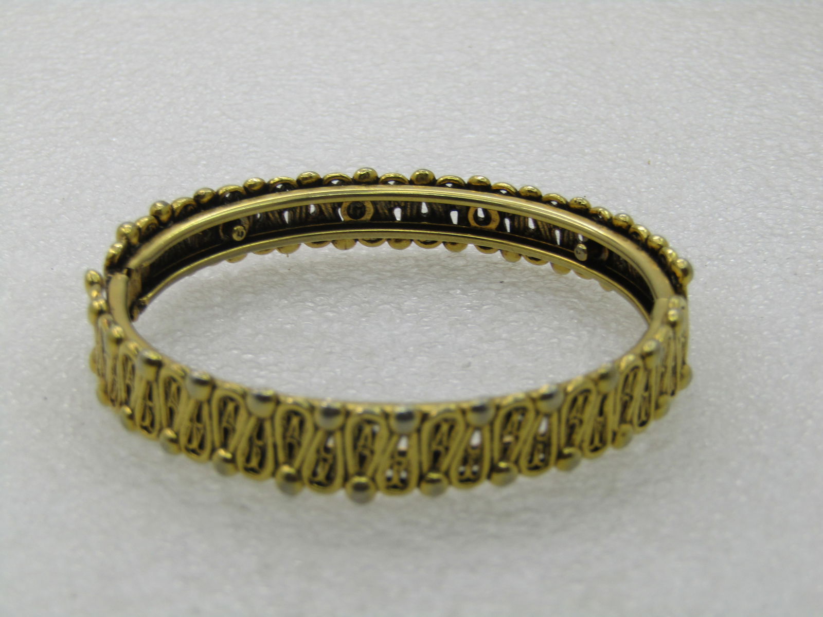 Vintage Gold Tone Hinged Bangle Bracelet, 7", 1960's: Vintage Gold Tone Hinged Bangle Bracelet, 7", 1960's and appx. 1/2" wide. Zigzag pattern with dotted accents around the bracelet with locking clasp. Opening measures appx. 2.5". Good condition to very