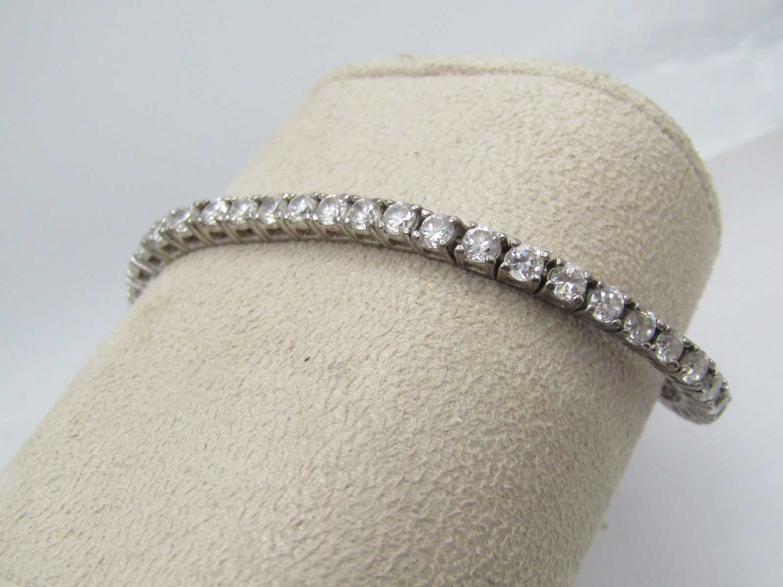 Sterling CZ Tennis Bracelet, 7.25" . Signed HAN: Sterling CZ Tennis Bracelet, 7.25" . Signed HAN and marked .925 and also marked China. This has appx. fifty 3mm round clear CZs. Box clasp with safety locks on each side. It tests as sterling with