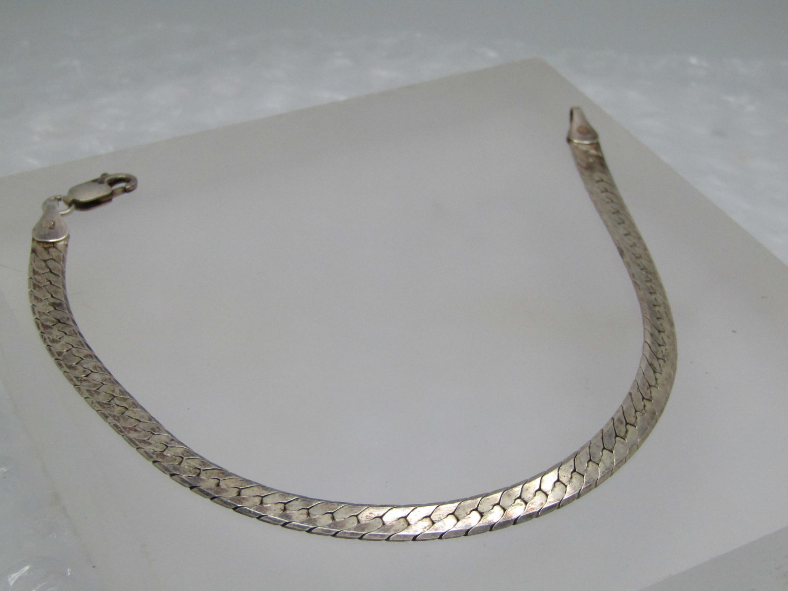 Vintage Sterling 5mm Herringbone Bracelet, 8", Signed, Unisex: Vintage Sterling 5mm Herringbone Bracelet, 8", Signed, Unisex, 1980's-1990's. Beveled edge. This is signed with an F in a stylized designed maker's mark. Unknown maker. Lobster clasp. Very good
