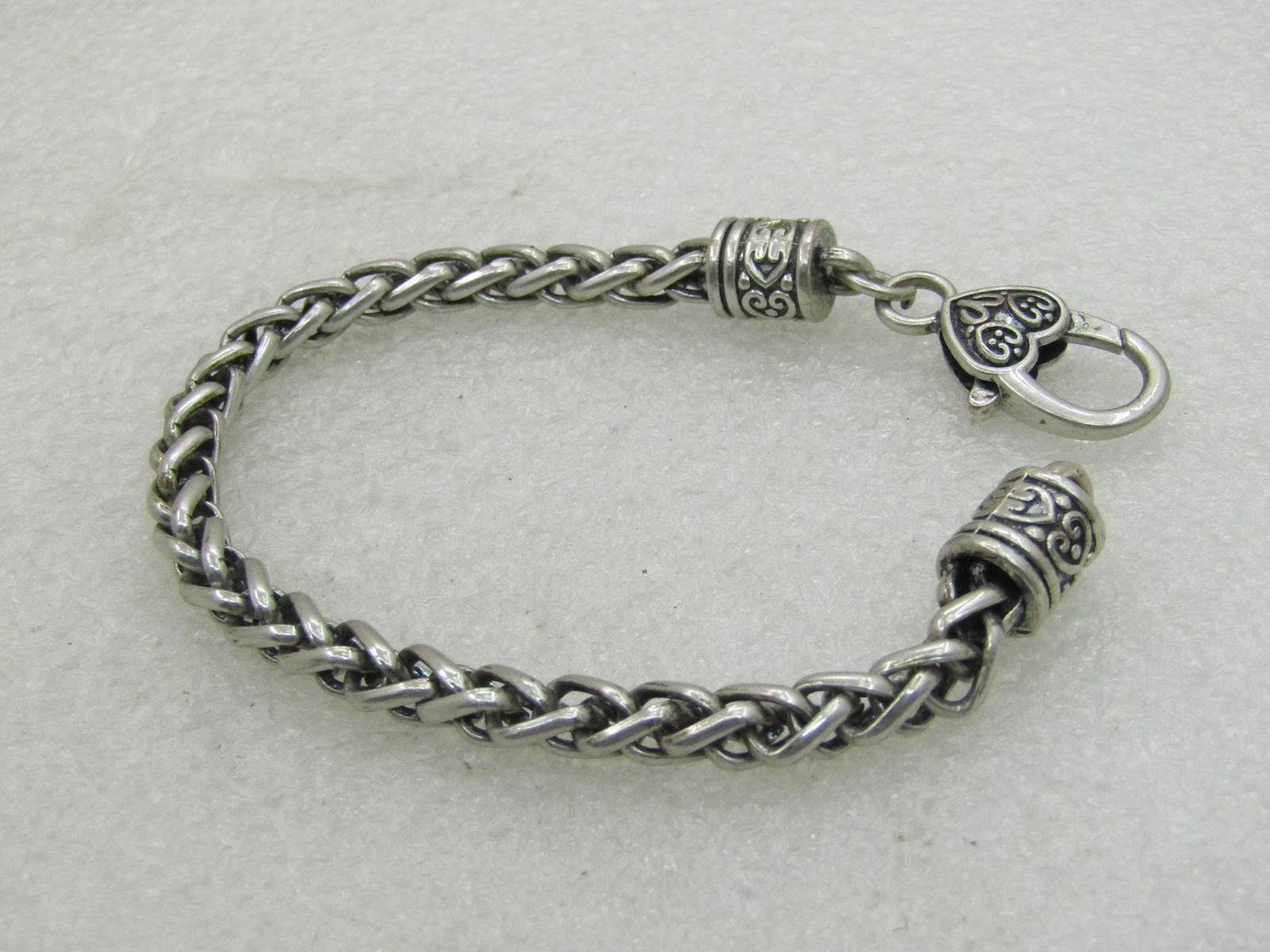Silver Plated Tone Heavy Link Bracelet, Heart Lobster Clasp, 7.75": Silver Plated Tone Heavy Link Bracelet, Heart Lobster Clasp, 7.75"m 5.5mm thick with heart accented end caps where the clasp and loop are. This is a wheat-like weave style chain. Heavy lobster clasp t