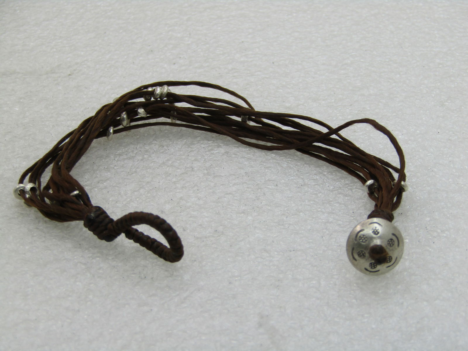 Vintage Brown Multi-Cord Beaded Bracelet, Tribal, Boho, 8", Loop Clasp: Vintage Brown Multi-Cord Beaded Bracelet, Tribal, Boho, 8", Loop Clasp. 11 brown cords with sliding silver tone disc beads. Stamped bead at the end where the loop slides over to close the bracelet -