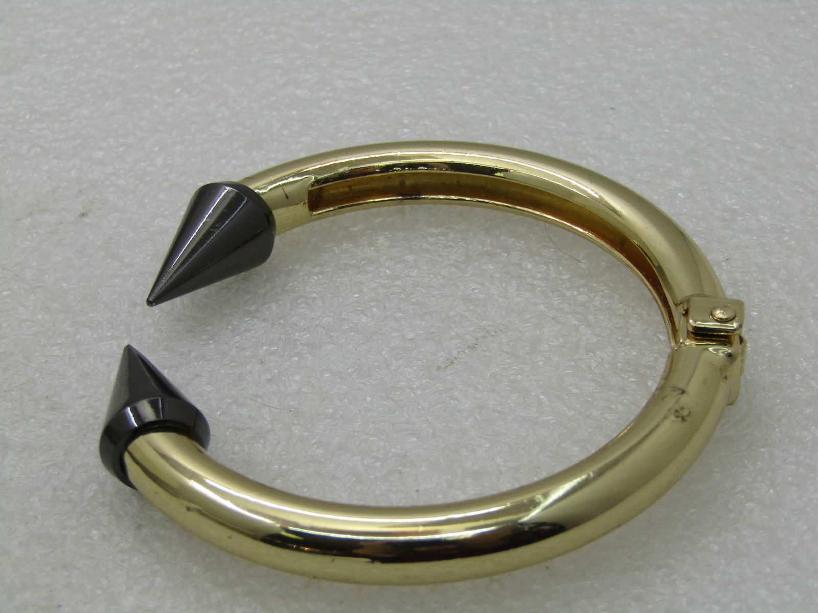 Vintage Titanium & Gold Tone Hinged Clamper Bracelet, 7", Modern/Futuristic Design NL: Vintage Titanium & Gold Tone Hinged Clamper Bracelet, 7", Modern/Futuristic Design. The titantium toned pointed end caps are set on appx. 8mm rounded gold tone hinged metal. Looks new. It is not signe