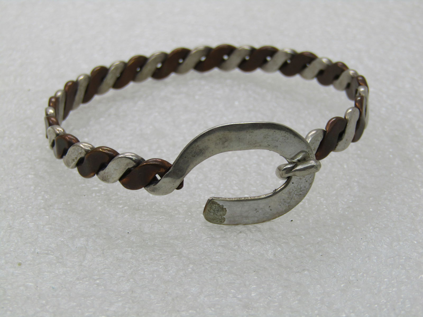 Vintage Sterling & Copper Bangle Bracelet, 7.5", Hook buckle clasp.: Vintage Sterling & Copper Bangle Bracelet, 7.5", 19.57 grams and 6.5mm wide. The opening is 2.5". This is an angled alternating braid of sterling and copper. It has a belt-like hook clasp in sterling