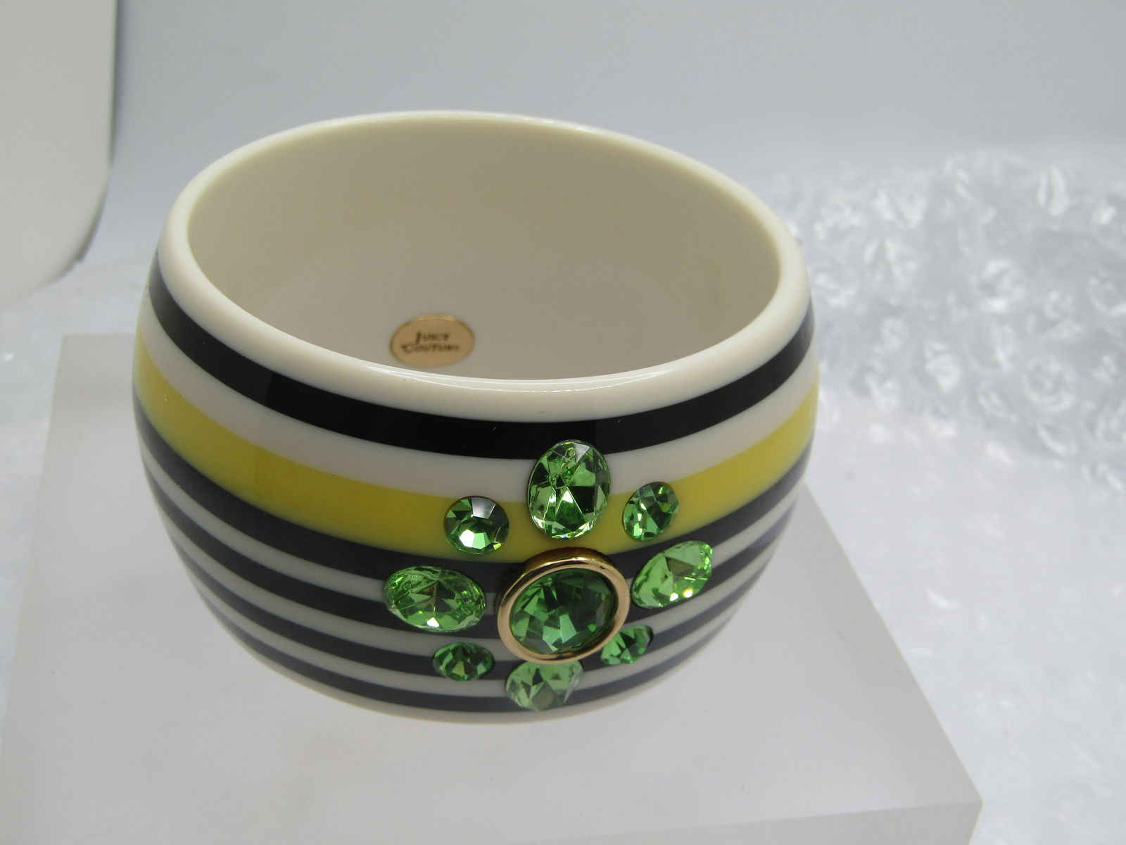 Juicy Couture Bangle Bracelet, Black/Yellow Striped, Green Rhinestones, 7.25": juicy Couture Bangle Bracelet, Black/Yellow Striped, Green Rhinestones, 7.25" with an opening of appx. 2.5". 1.75" wide and slightly domed. Peridot green colored rhinestone blossom on the outside