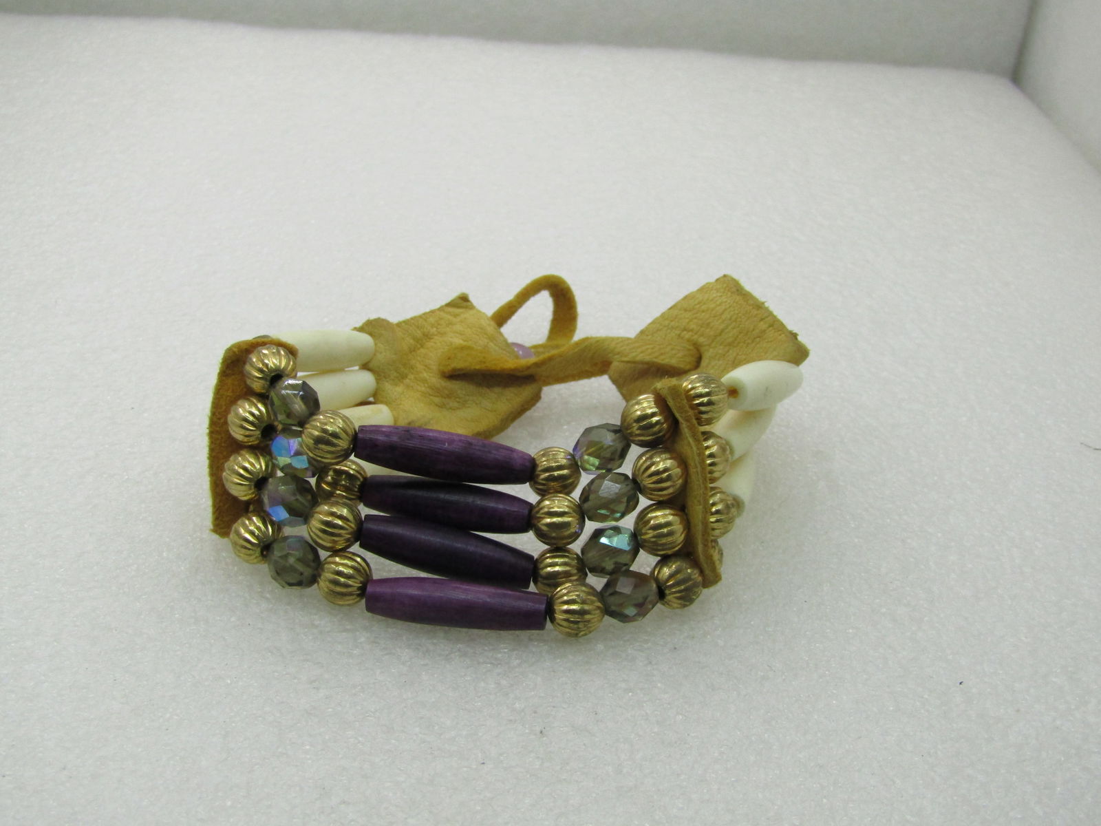 Vintage Southwestern Modern Tribal Bracelet, Adjustable: Vintage Southwestern Modern Tribal Bracelet, Adjustable. Four strands that have antelope-like 1" tube beads in natural color and purple dyed in the center. There are fluted or ridged 7.5mm gold tone b