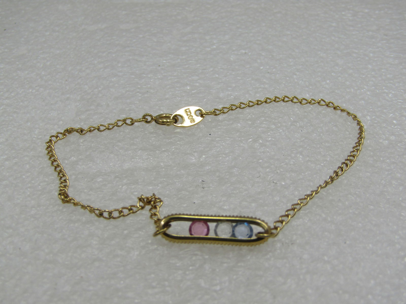 Vintage Gold Tone Floating CZ Anklet/Bracelet 8.75" Avon: Vintage Gold Tone Floating CZ Anklet/Bracelet 8.75" Avon. 3/4" long open oval that is appx. 5mm with a flaoting pastel pink, blue and clear cz in the center. Spring clasp. 1980's-1990's. Signed Avon.