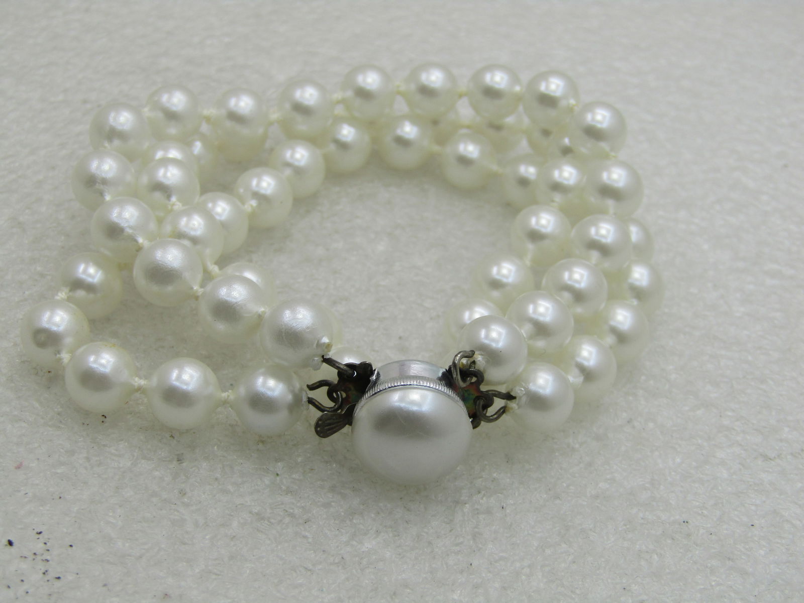 Vintage Triple Strand Faux Pearl Bracelet, Hong Kong, 7.5": Vintage Triple Strand Faux Pearl Bracelet, Hong Kong, 7.5" with a pearl box clasp. Three strands of appx. 7.5mm white pearls that have a knot between each costume pearl. This is in very good condition