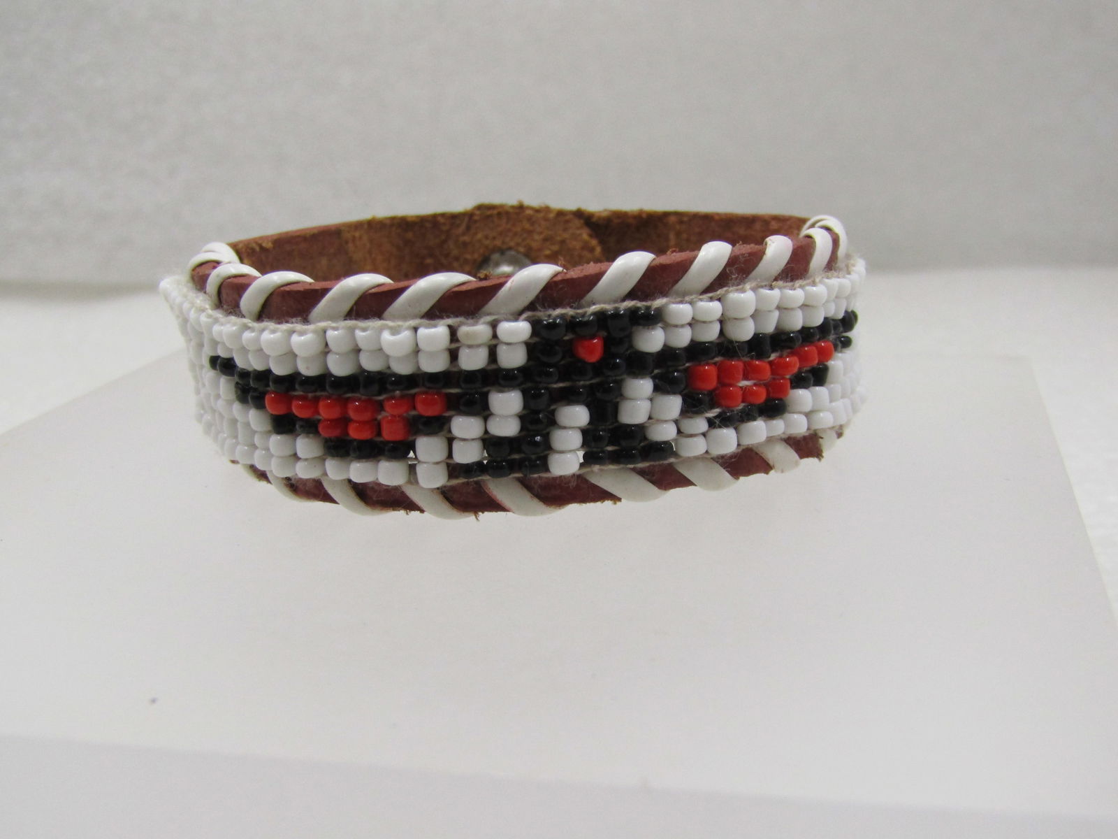Vintage Southwestern Thunderbird Beaded Leather Bracelet, 6": Vintage Southwestern Thunderbird Beaded Leather Bracelet, 6" long with snap clasp in closed position and 3/4" wide. This has white wraps around the edges of the bracelet around appx. two-thirds of the