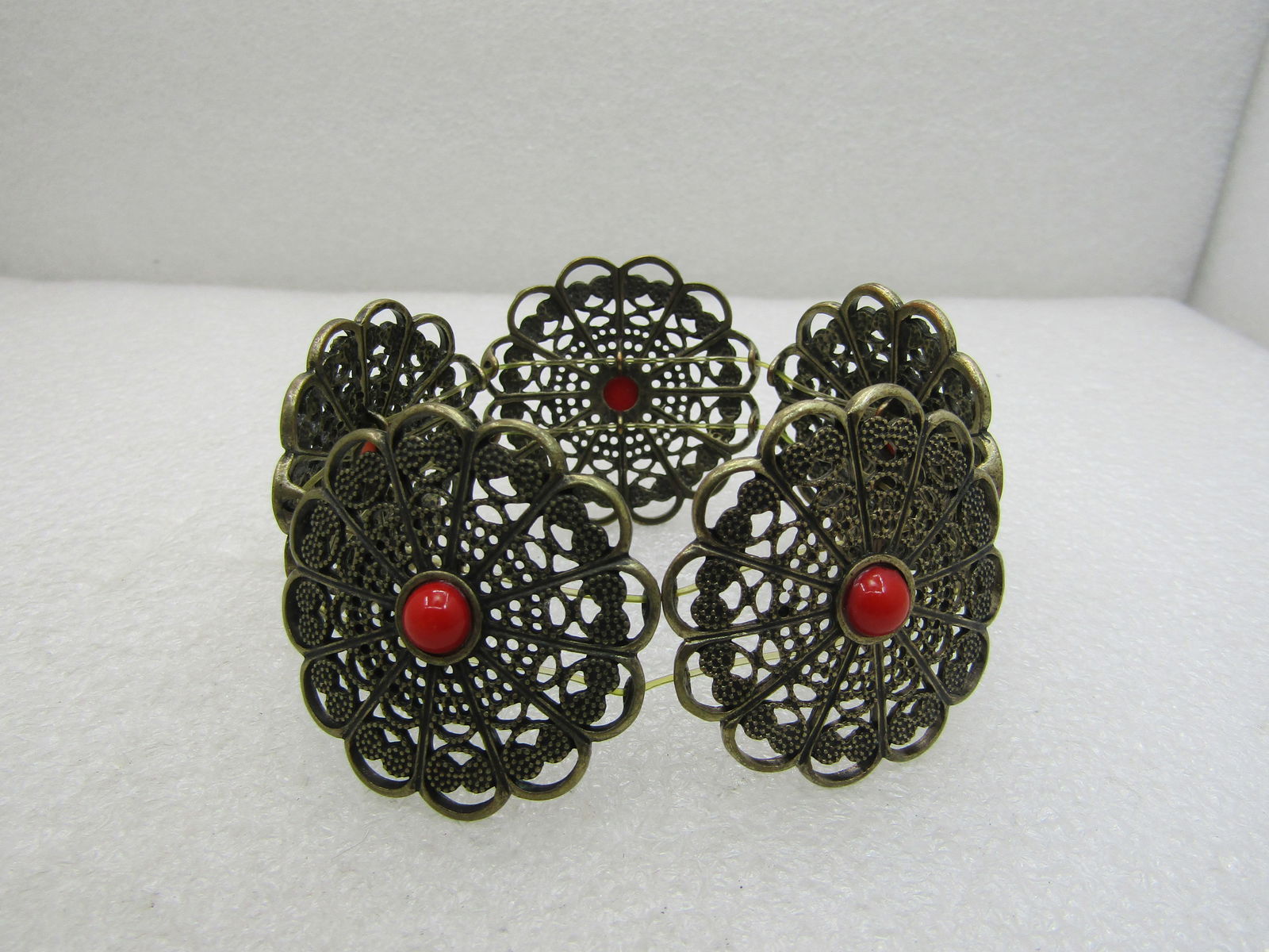 Vintage Brass Blossom Stretch Bracelet with Red Cabochon. 7": Vintage Brass Blossom Stretch Bracelet with Red Cabochon. 7", This has five 1.5" slightedly domed blossoms, each with two loops on the edges and center for stringing. THIS DOES NEED TO BE RESTRUNG .