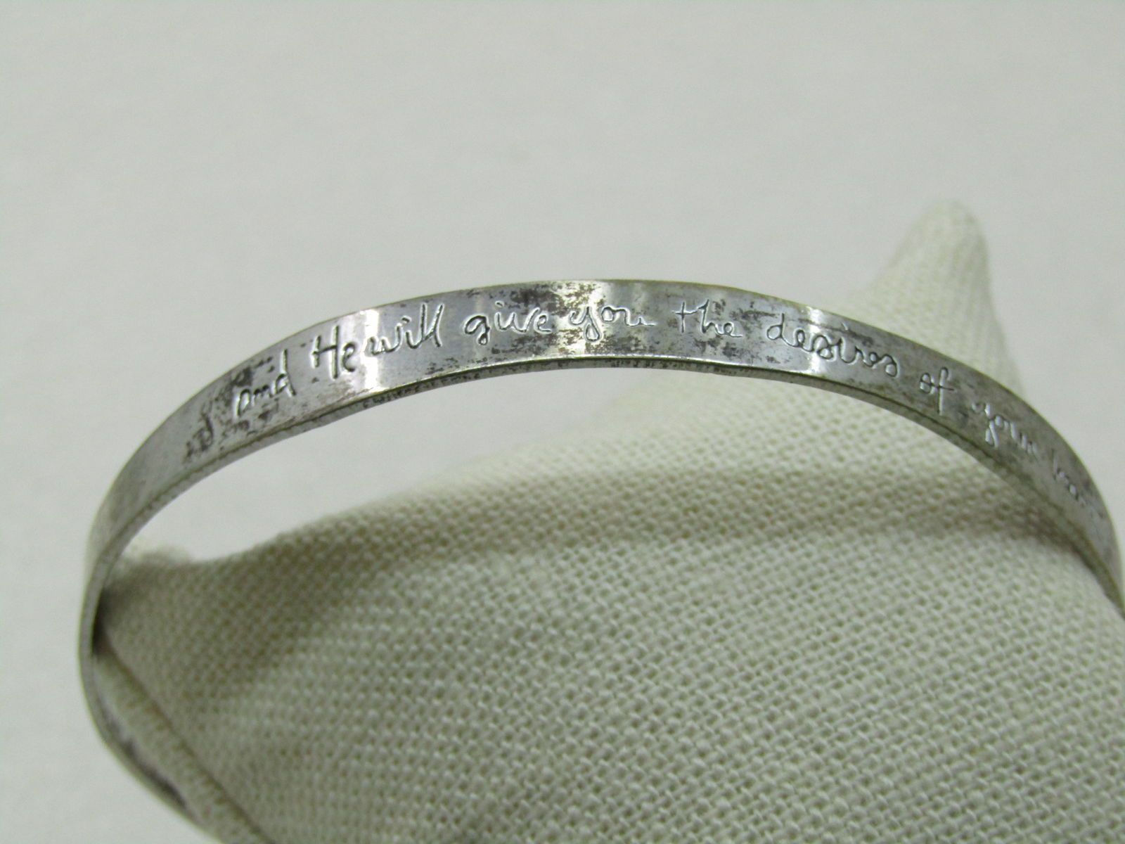 Vintage "And He Will Give You the Desires of Your Heart" Bangle Bracelet, 8.75": Vintage "And He Will Give You the Desires of Your Heart" Bangle Bracelet, 8.75". It has a wavy design that is 7.4mm wide in some spots and 5mm in other spots. The writing is recessed. It has a maker's