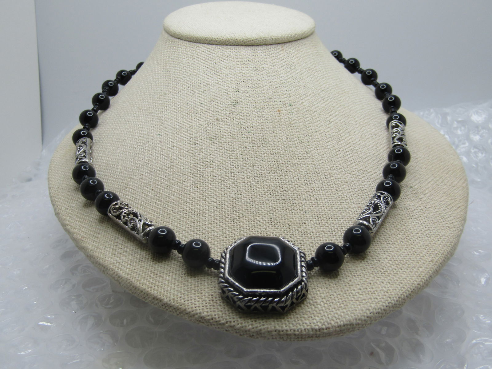 Black Beaded & Scrolled Necklace, 21.5", Silver Tone, 1990's: Black Beaded & Scrolled Necklace, 21.5", Silver Tone, 1990's. They have a southwesternish theme. This has a main pendant that is eight sides with a black domed seonte in the center, open silver tone o