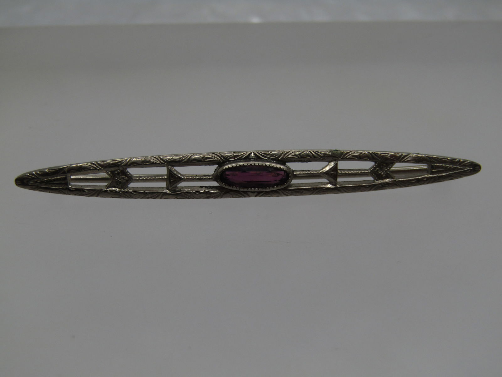 Vintage Pointed Bar Brooch, Purple Stone, 2.25" Signed G.T.: Vintage Pointed Bar Brooch, Purple Stone, 2.25", C-Clasp Signed G.T. It s has a c-clsp, is testing as 10kt G.F. It has a bezel-set purple stone that does not test as amethyst - likely glass. It does n