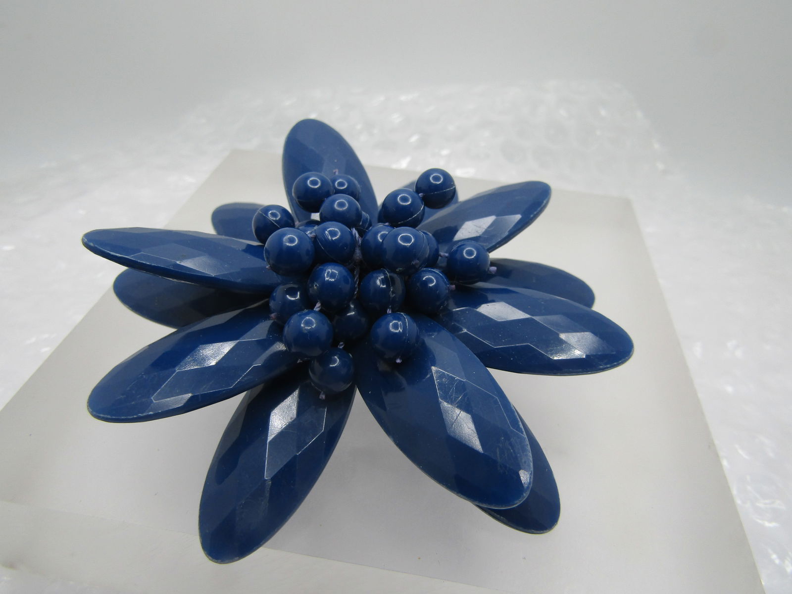 Vintage Blue Faceted Floral Brooch, Lucite, 3.25": Vintage Blue Faceted Floral Brooch, Lucite, 3.25", Age us appx. mid-century. This has three tiers of long faceted petals and cluster of blue beads springing out from the center. Brassy pinback
