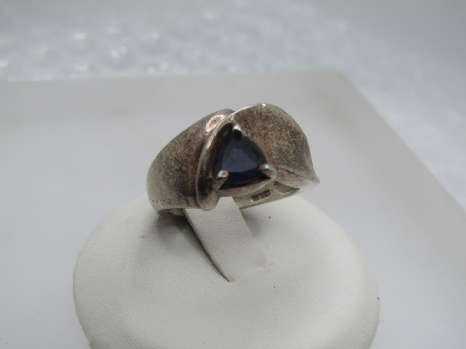 Vintage Sterling Blue Stone Ring, Sz. 5.5, Triangular: Vintage Sterling Blue Stone Ring, Sz. 5.5, Triangular stone that is appx. 4.5mm down each side, held with prongs. It has a wide band design with a wrapped or bypass type of design that is domed and