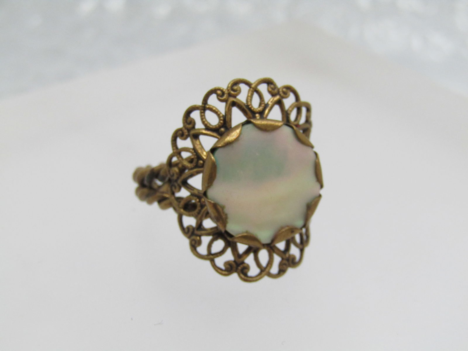 Vintage Mother-of-Pearl Brass Ring, Western German, Adjustable, Late 1940's-1960's: Vintage Mother-of-Pearl Brass Ring, Western German, Adjustable, Late 1940's-1960's. This has a round 14mm mother-of-pearl round bezel-set top with scalloped bezel and is set over a filigree setting