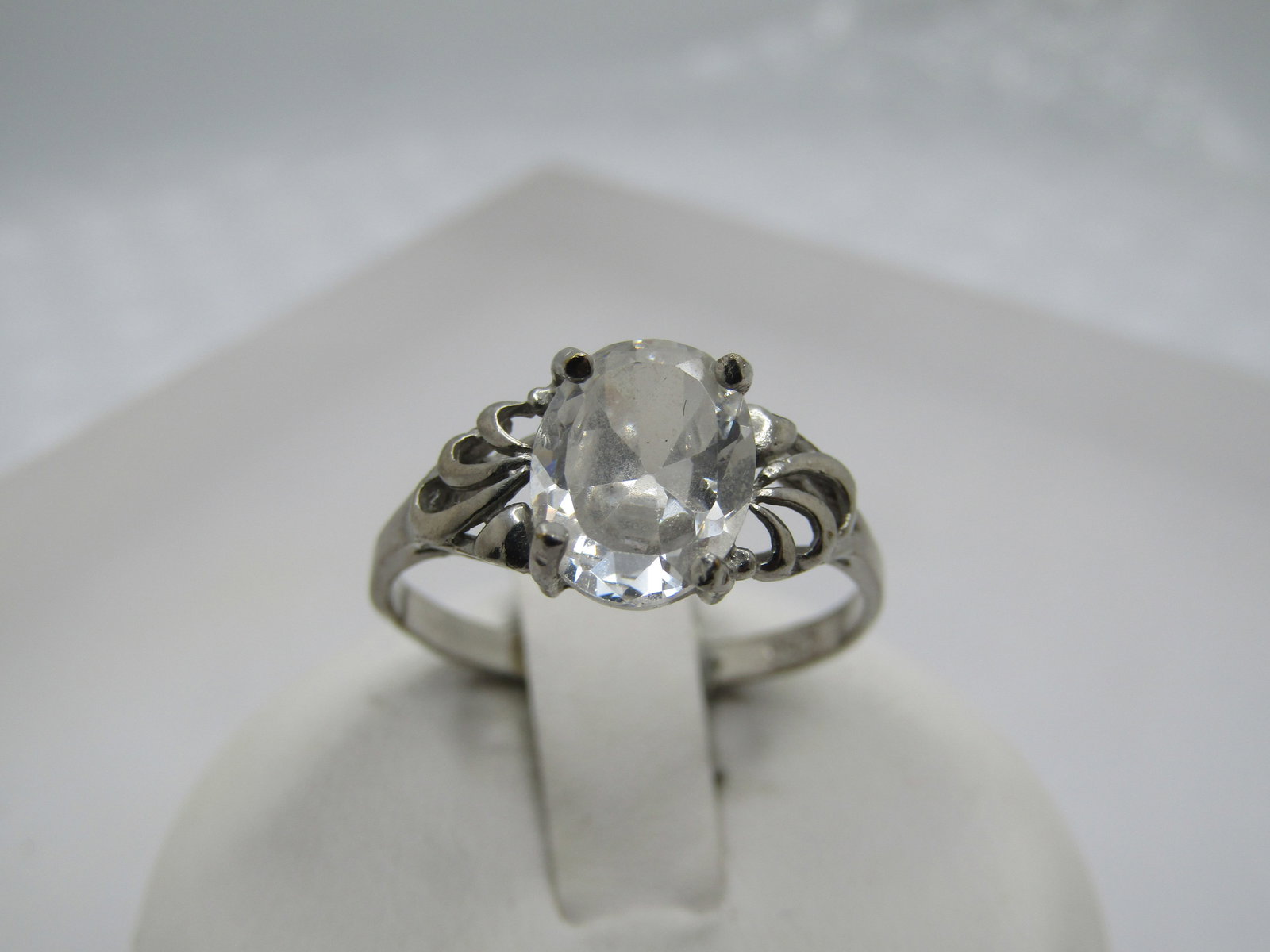 Vintage Silver Plated Clear Stone Ring, Sz. 8: Vintage Silver Plated Clear Stone Ring, Sz. 8. It has an oval clear stone that is appx. 8.5mm by 6.5mm with open curved accents on ech side. The band is appx. 2mm at the back of the finger. It is