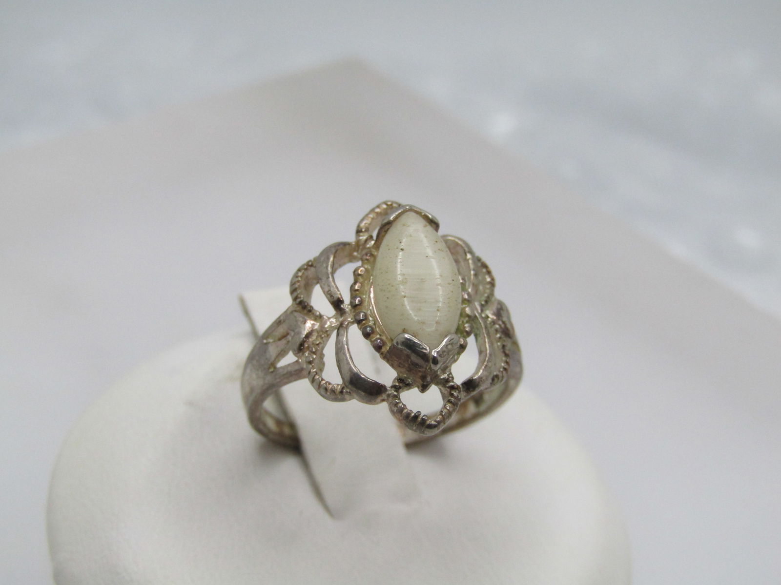 Vintage Silver Plated Faux Opal Ring, Sz. 6. Filigree: Vintage Silver Plated Faux Opal Ring, Sz. 6. Filigree. Marquise faux opal stone that is appx. 8mm by 5mm help with bezels on the point and a filigree open design around the stone. It is appx. 16mm dow