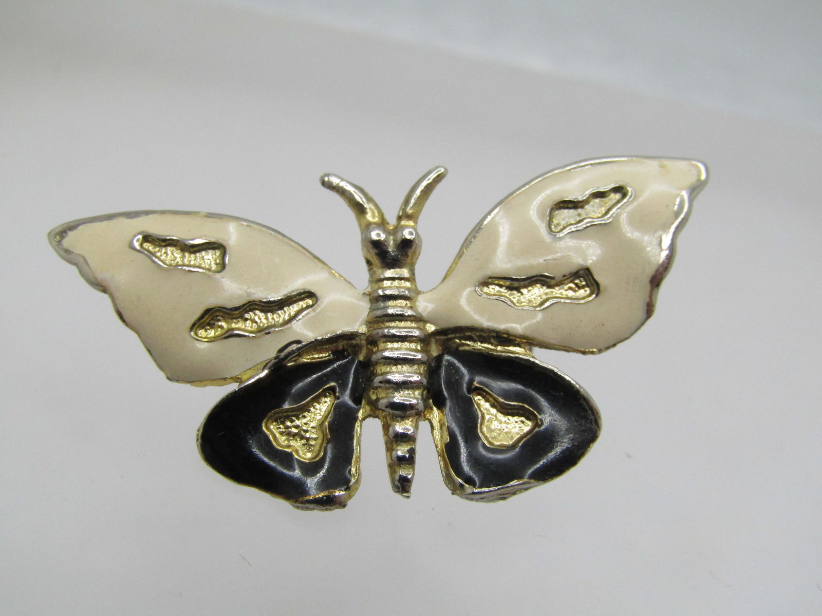 Vintage Enameled Butterfly Brooch, Black/White, 1970's/1980's.: Vintage Enameled Butterfly Brooch, Black/White, 1970's/1980's. Gold tone and app. 1.75" wide and 1" tall. Not signed by the maker. Very good condition. (NC12 SS9318 AZ (LD 1/14/23). Reserve: $15.00 Sh