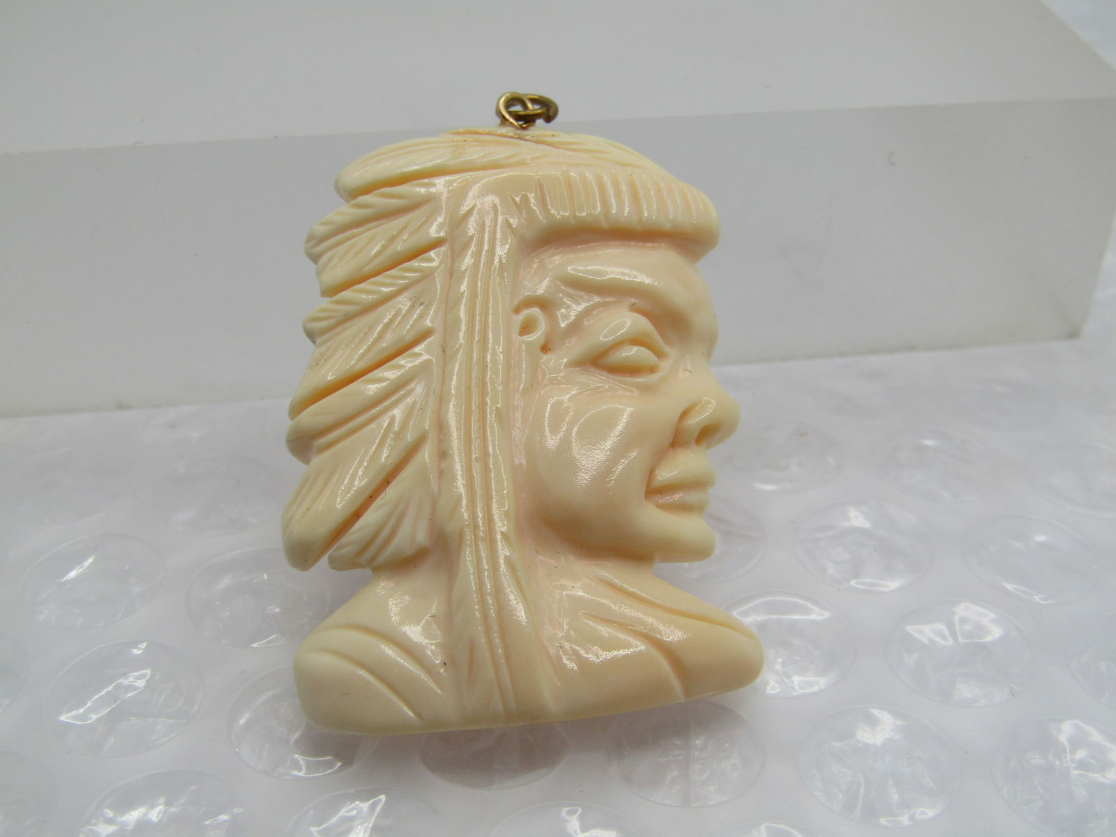 Vintage Glass Native American Chief Pendant, 1.75": Vintage Glass Native American Chief Pendant, 1.75" tall and 1.25" wide. Nice detail. It is not marked or signed. Age is estimated at 1970's-1980's . It does not react to a needle and stays cold