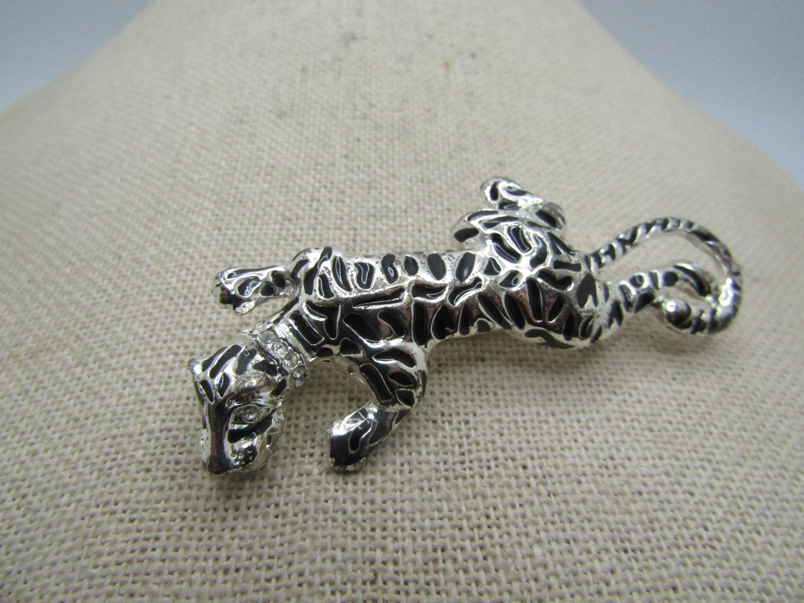 Enameled Tiger Brooch, Rhinestone Collar, 2.5": Enameled Tiger Brooch, Rhinestone Collar, 2.5". Silver tone metal in very good condition with enameled depressions creating the tiger striples, clear rhinestone eyes and collar. Not signed by the