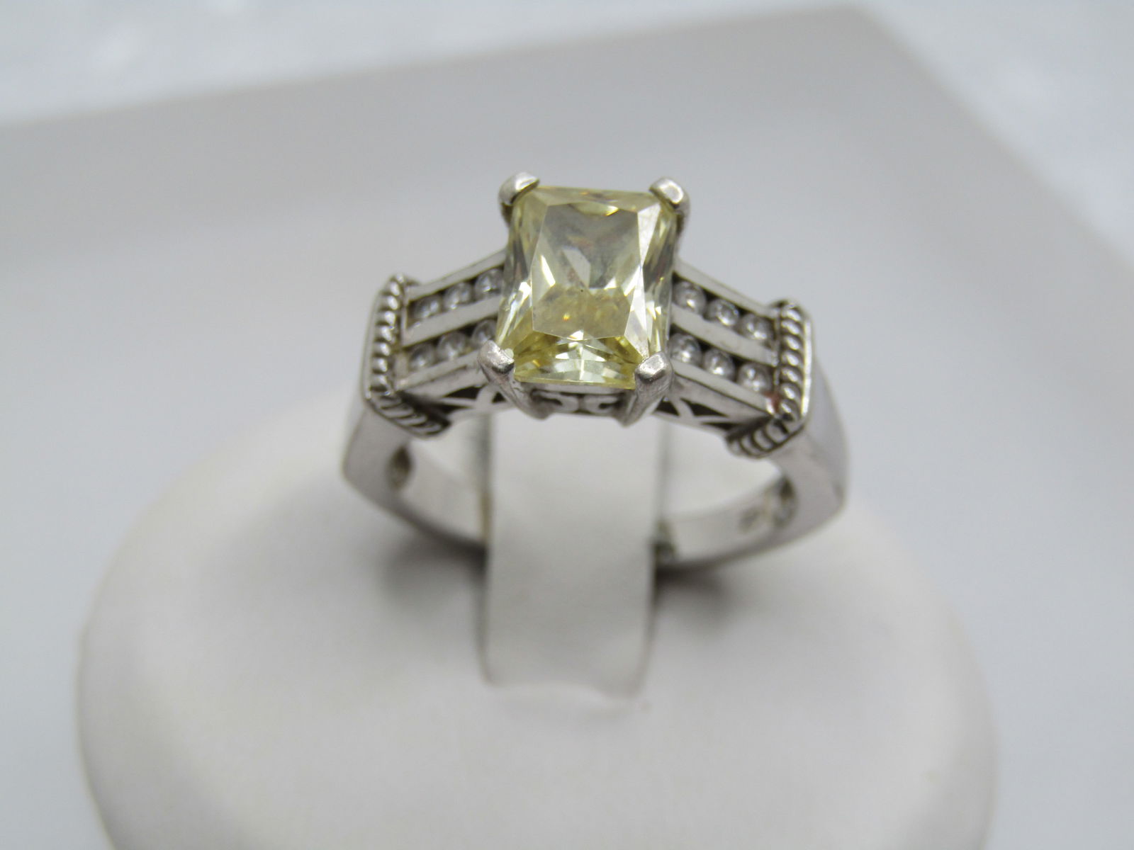 Sterling Silver Yellow/Clear CZ Ring, Sz. 6, Signed: Sterling Silver Yellow/Clear CZ Ring, Sz. 6, Signed. This has a yellow cz at top center and sitting higher. The stone is appx. 8mm by 6mm, prong set Below that is a double row of clear CZ's that are c
