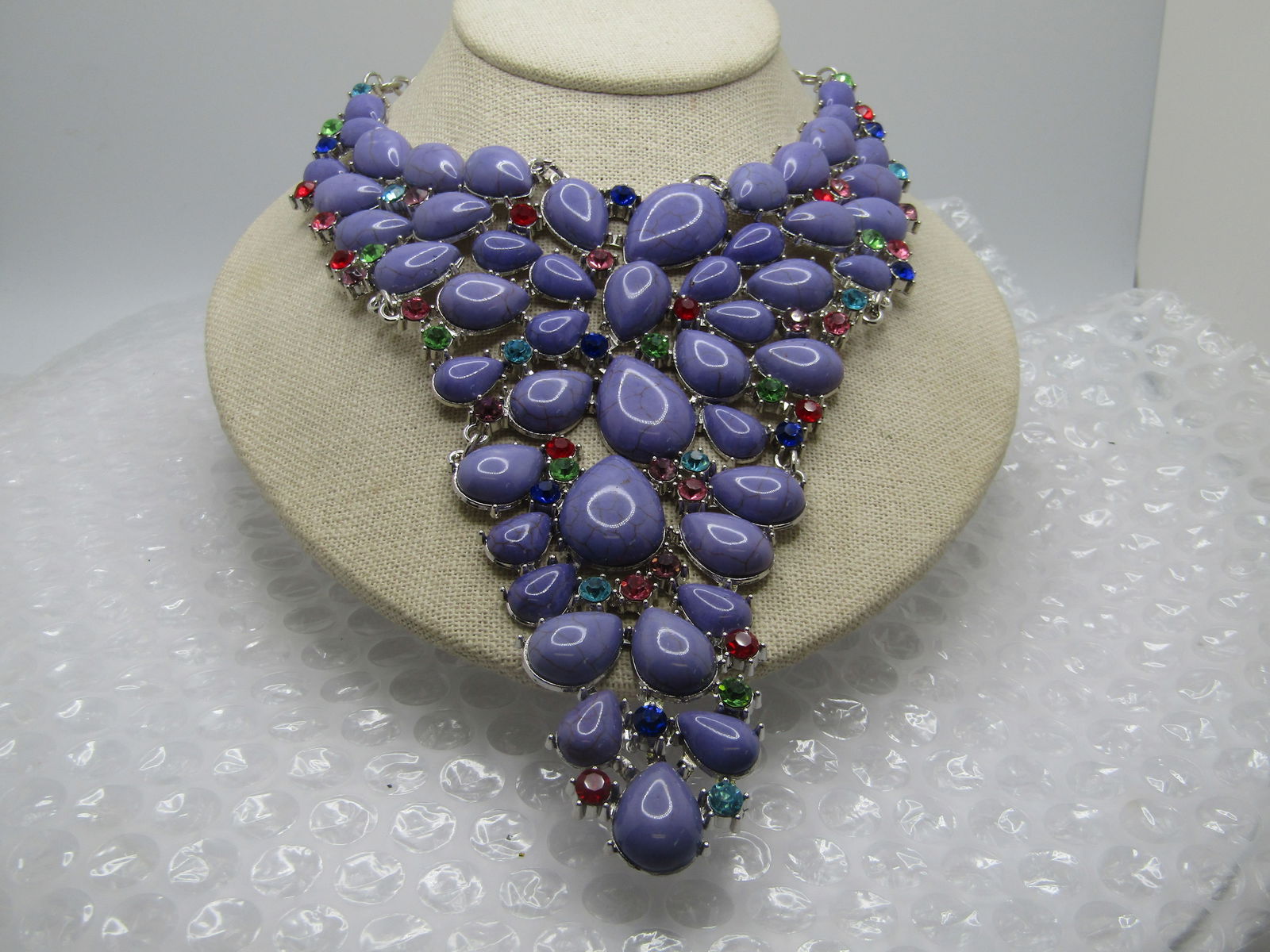 Costume Faux Purple Stone Statement Necklace, 22", Rhinestone Accents, 2000's: Costume Faux Purple Stone Necklace, 22", Rhinestone Accents, 2000's. Statement necklace. Current design with a larged curved and pointed bib drop with faux rounded purple stone (appear to be glass)